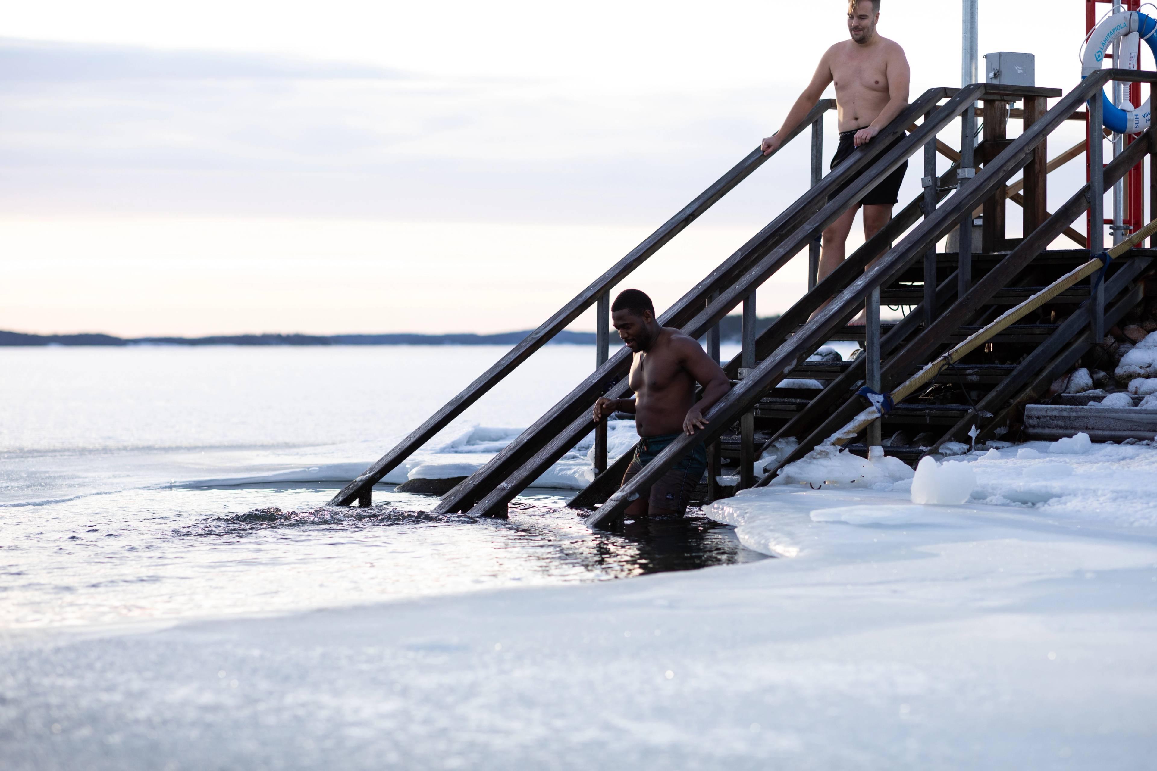 A person descending into the icy water.
