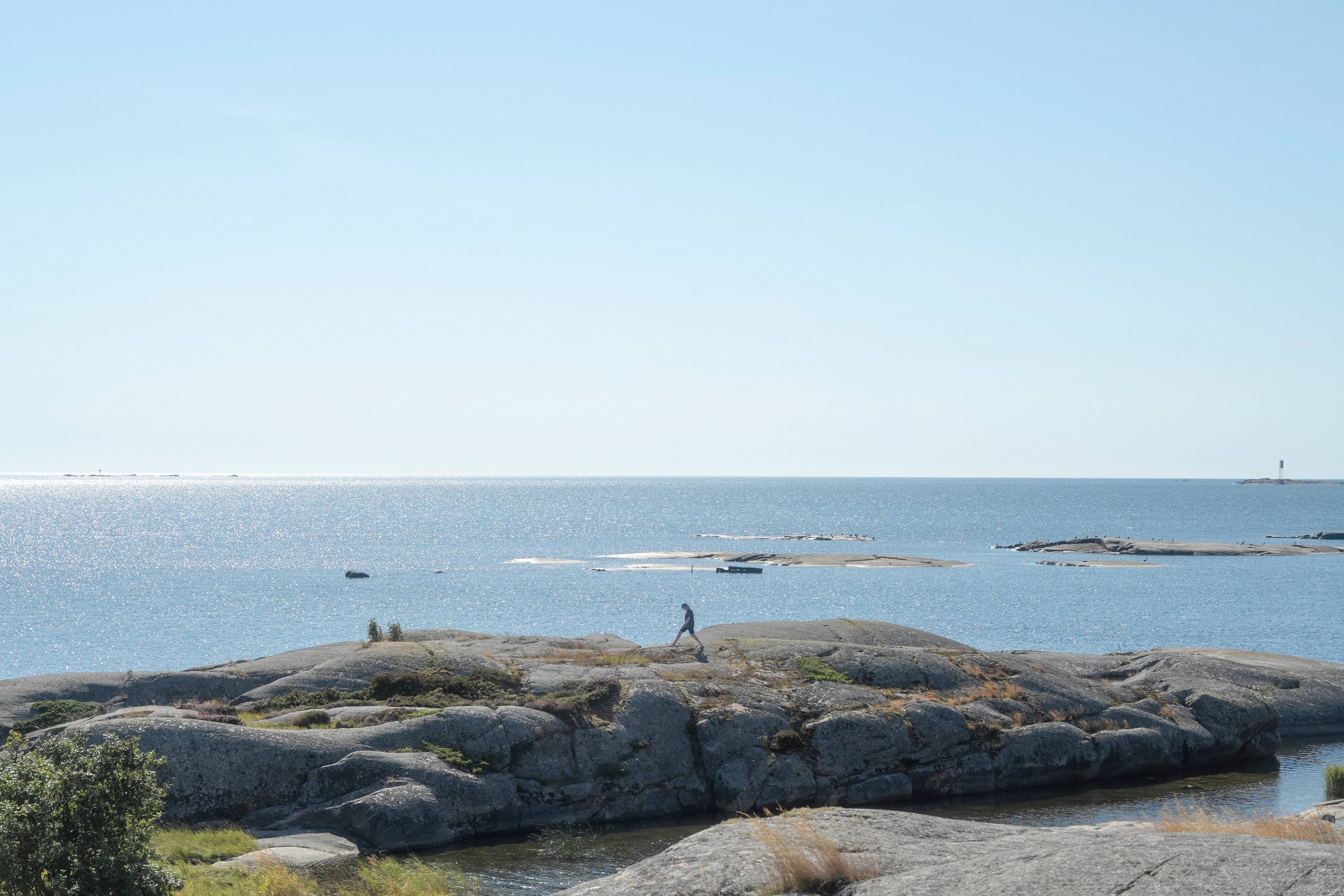 A person jumping on rocks in the Finnish Archipelago