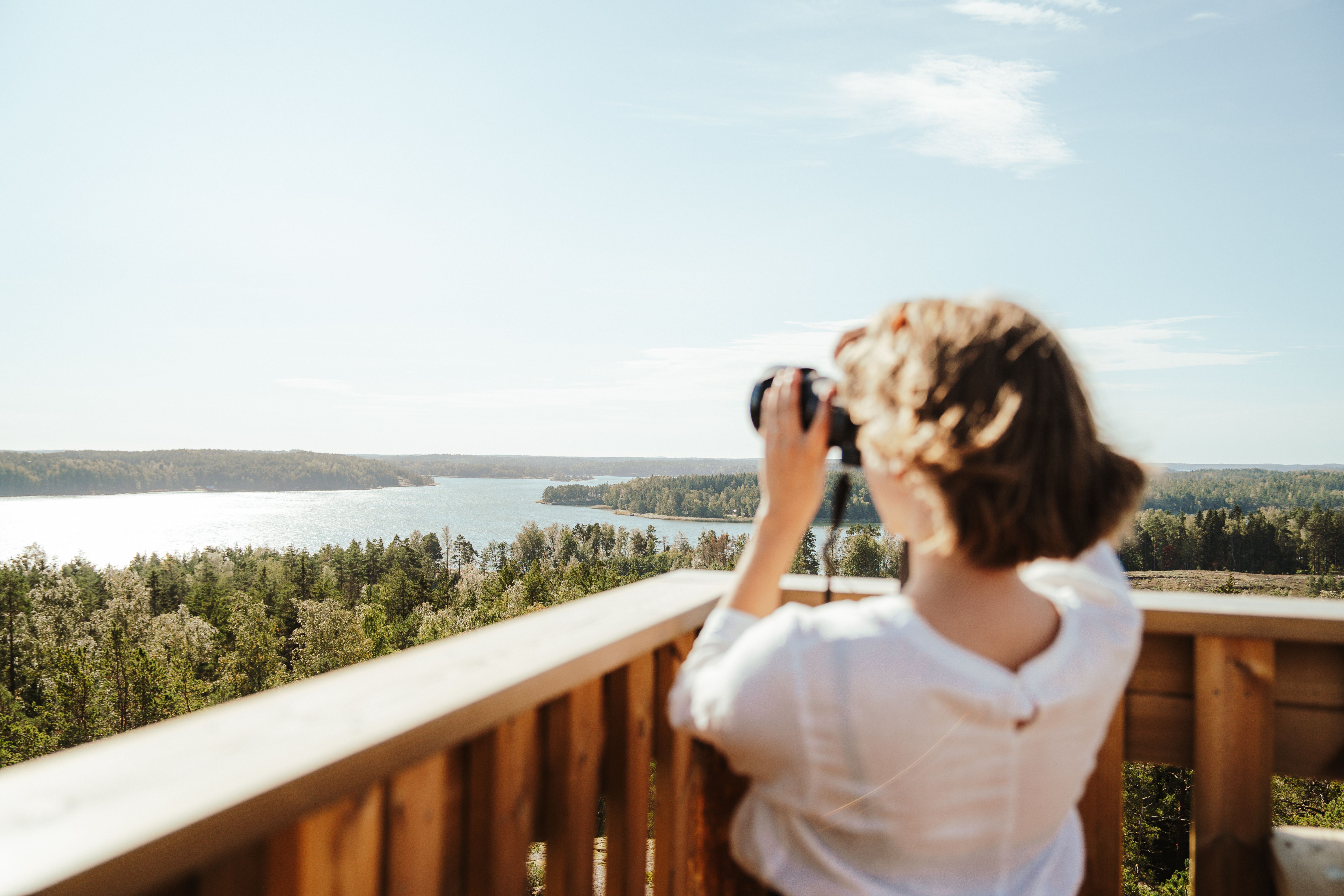 A woman looking at the archipelago through binoculars.