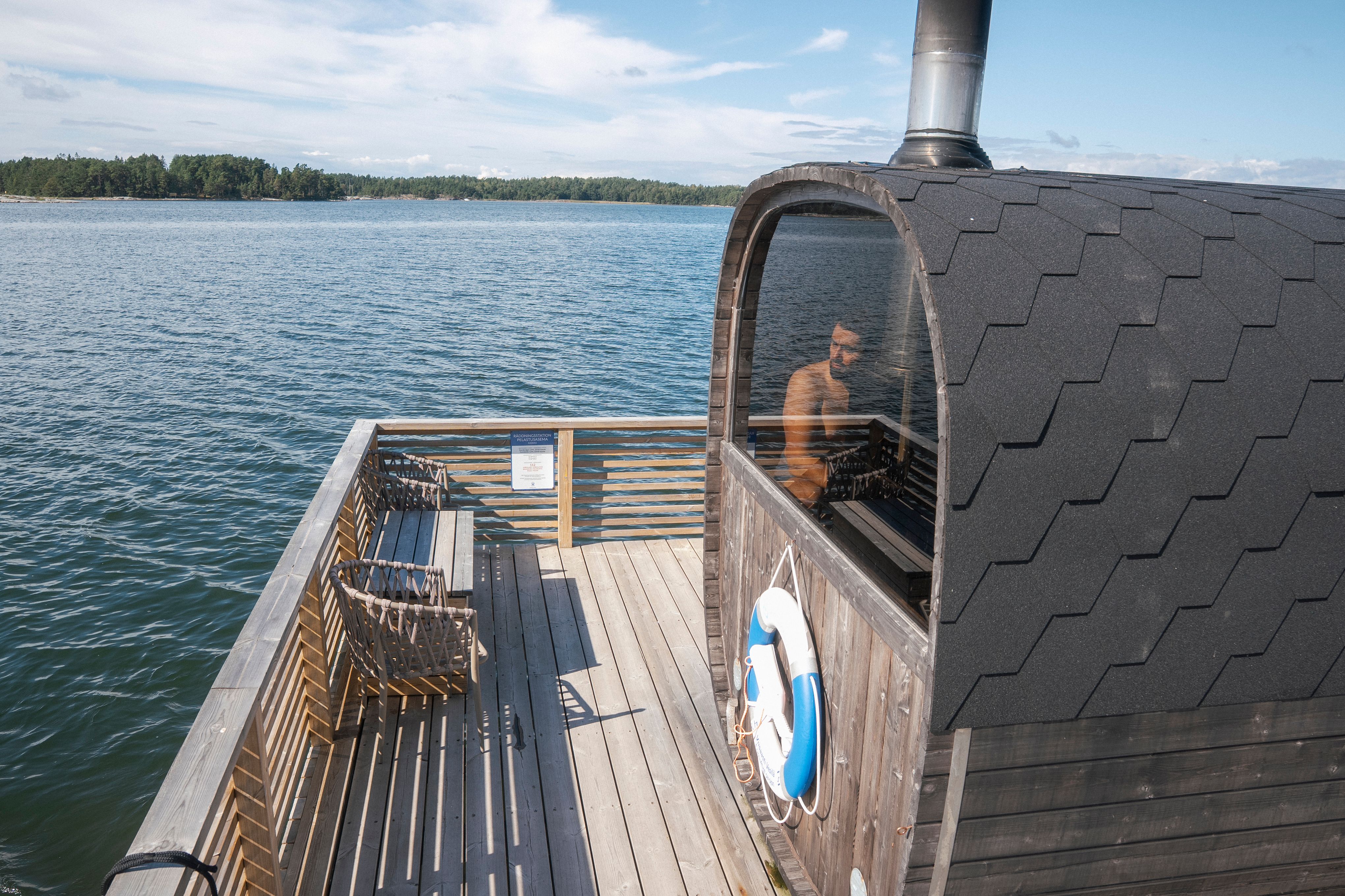 A man sitting inside a sauna on a dock.