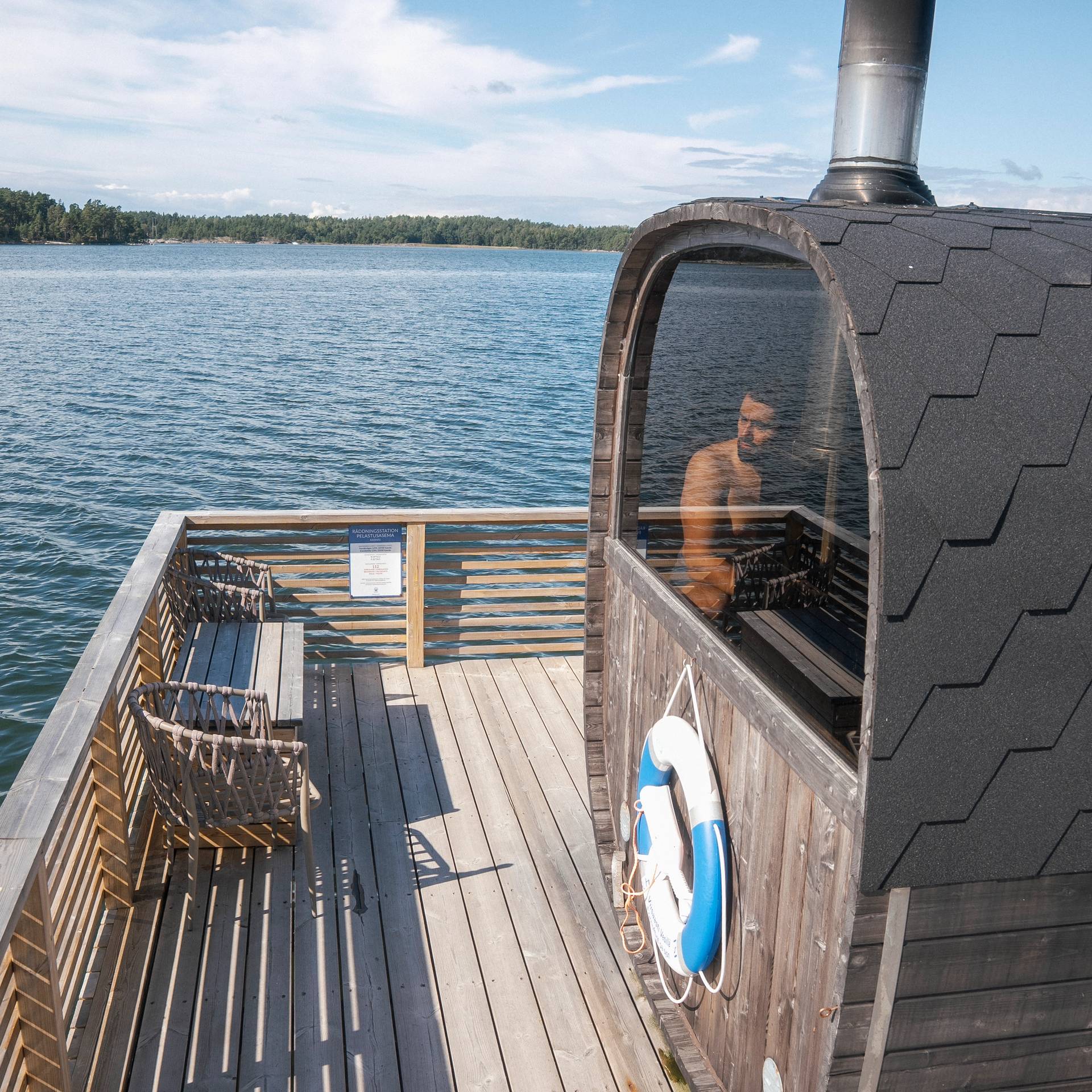 A man sitting inside a sauna on a dock.