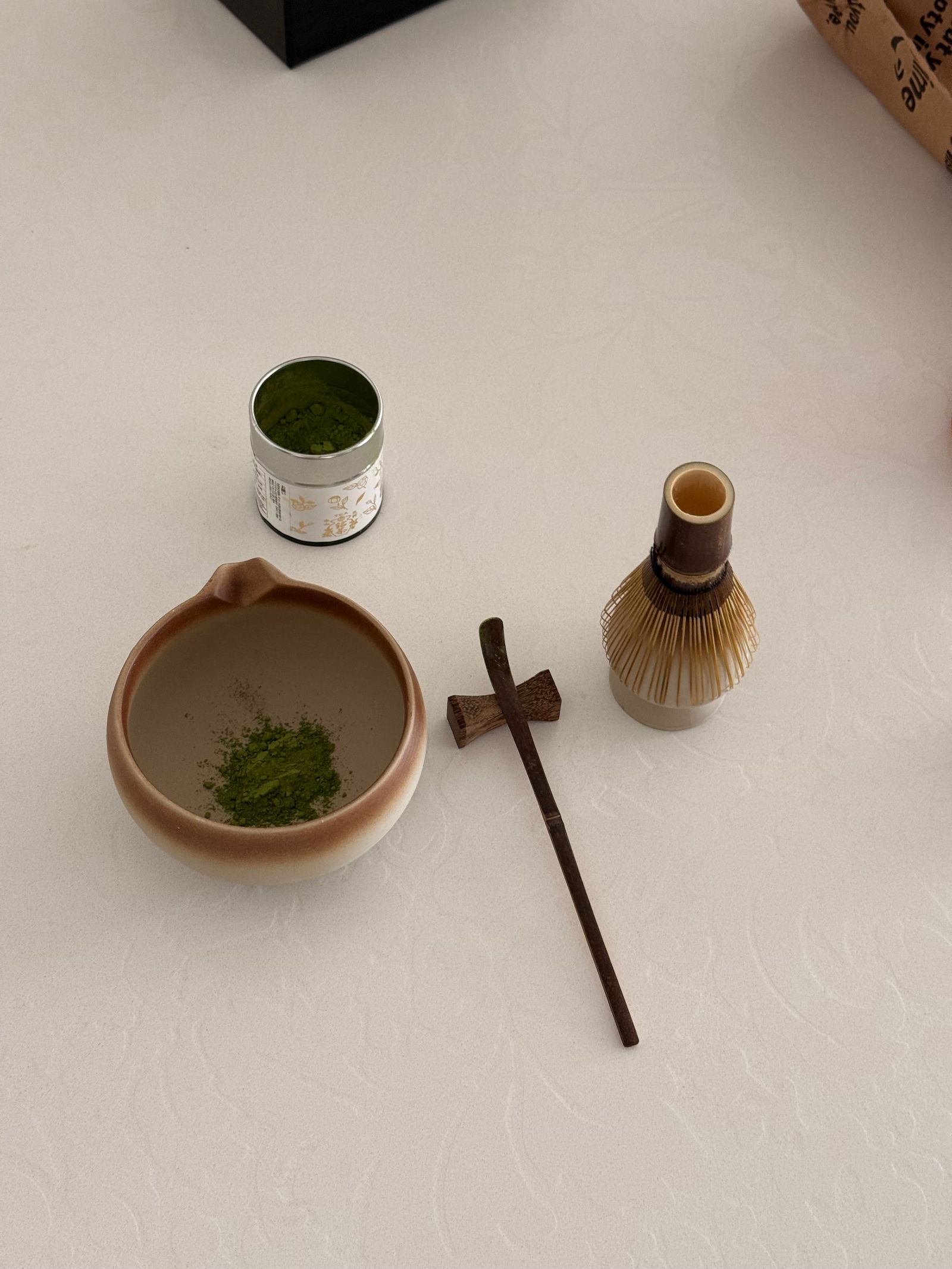 A flat-lay arrangement of traditional Japanese matcha tea preparation tools on a white surface.