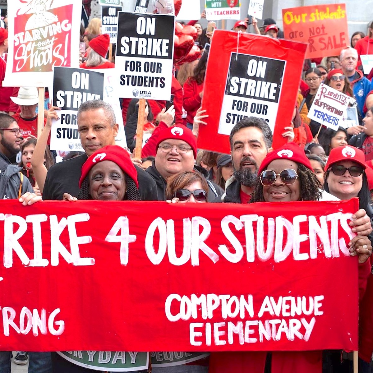 Striking workers hold signs that say "on strike for our students"