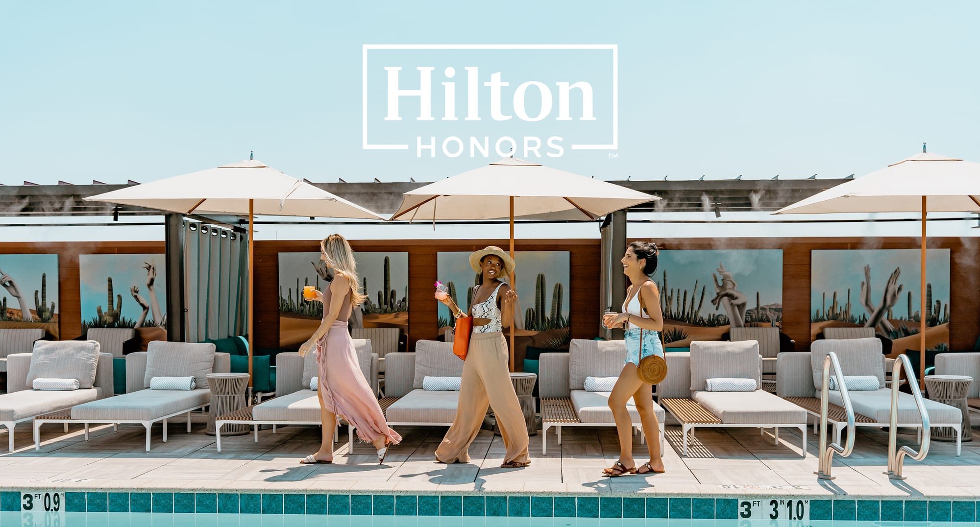 Guests beside a rooftop hotel pool with cabanas under the Hilton Honors logo