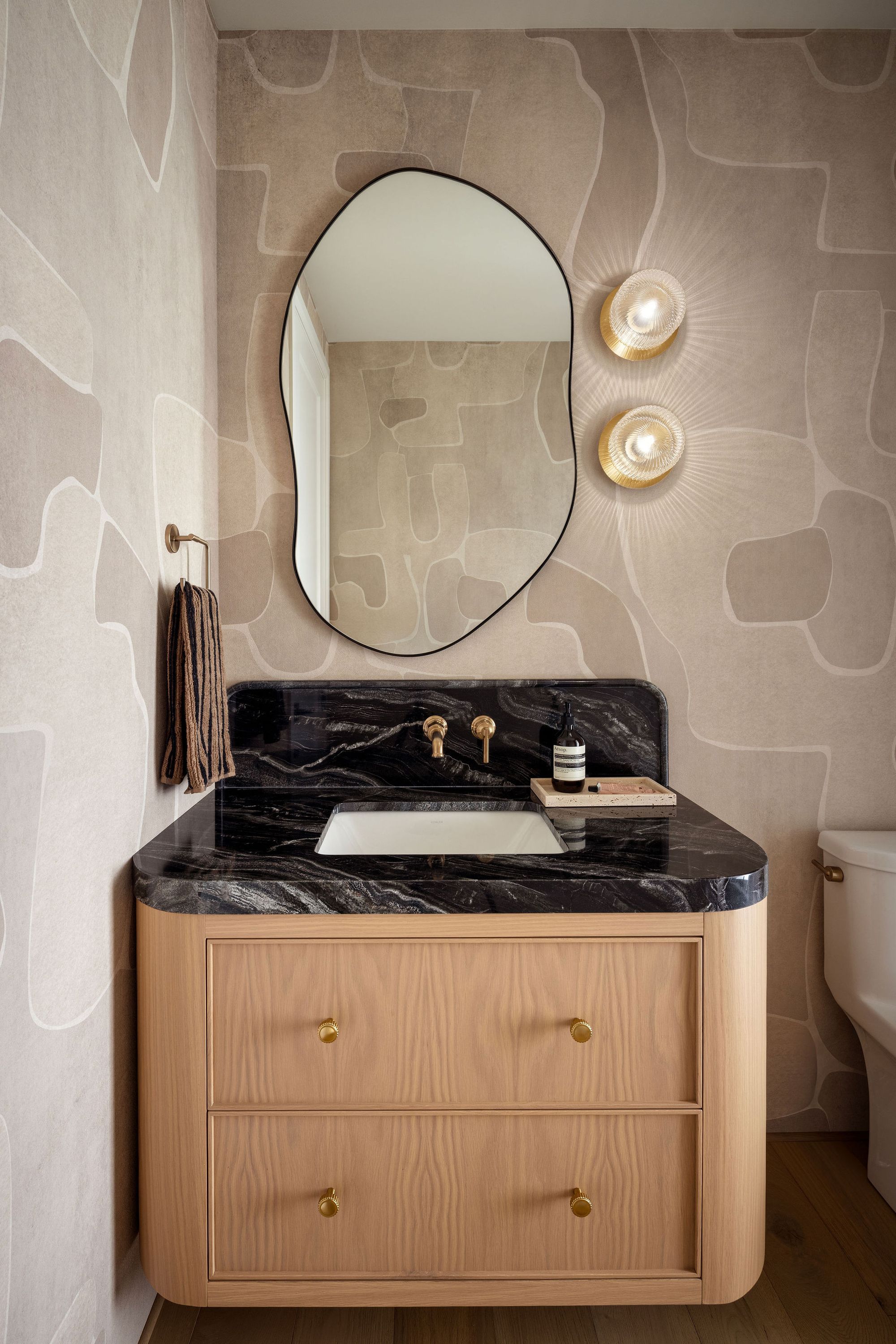 Powder room with oval mirror in The Charlotte home