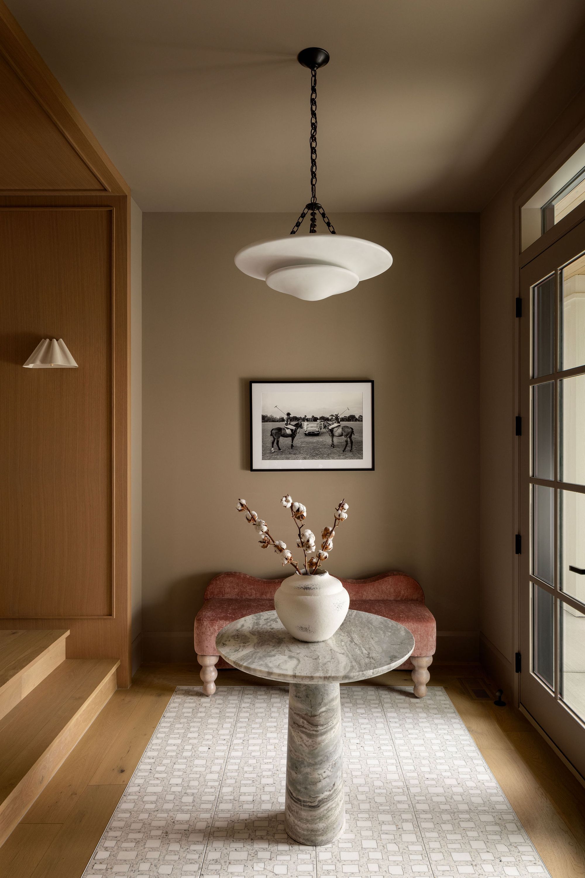 Entry with round marble table and bench in The Charlotte home