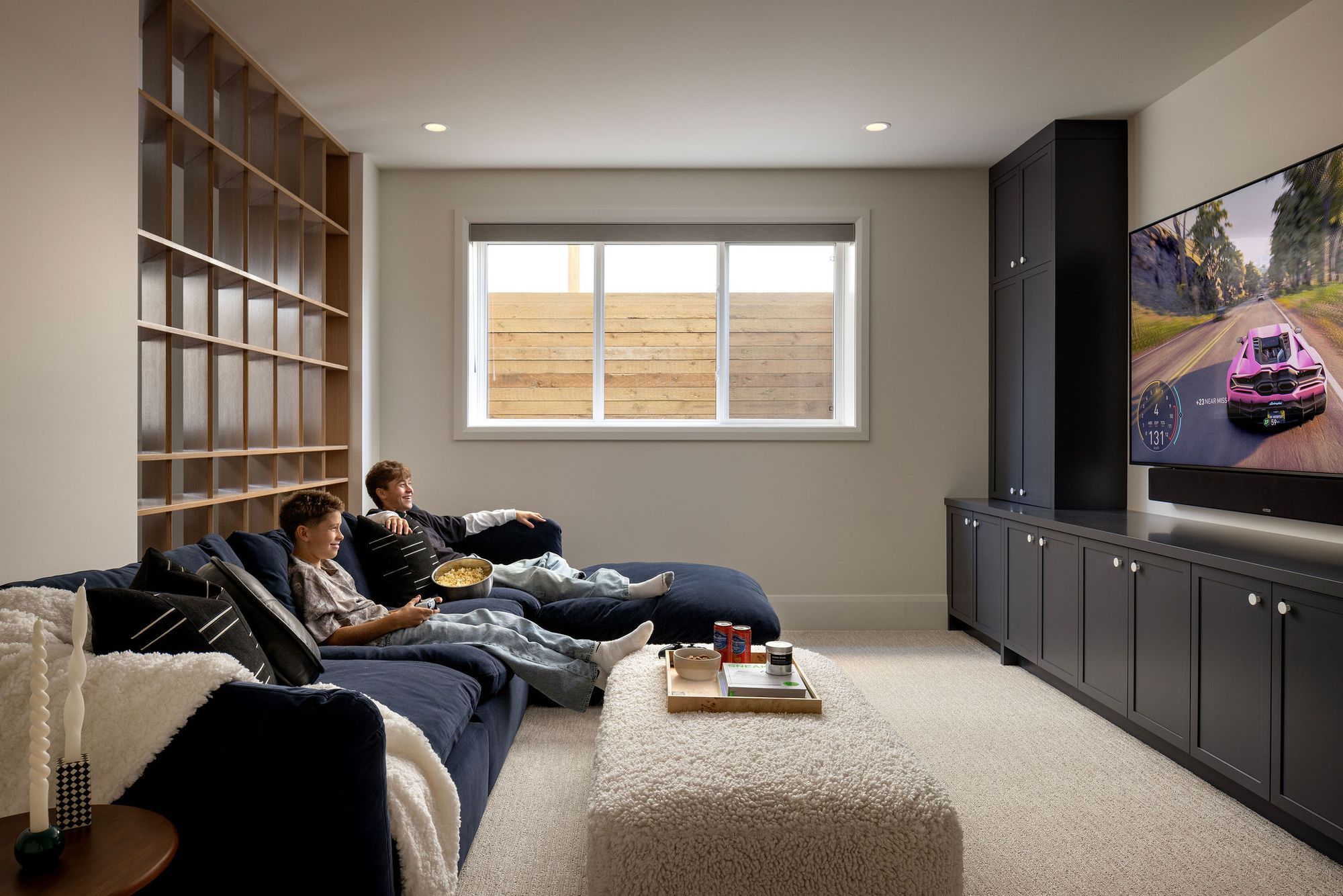 Media room with sectional sofa and built-in cabinets in The Charlotte home