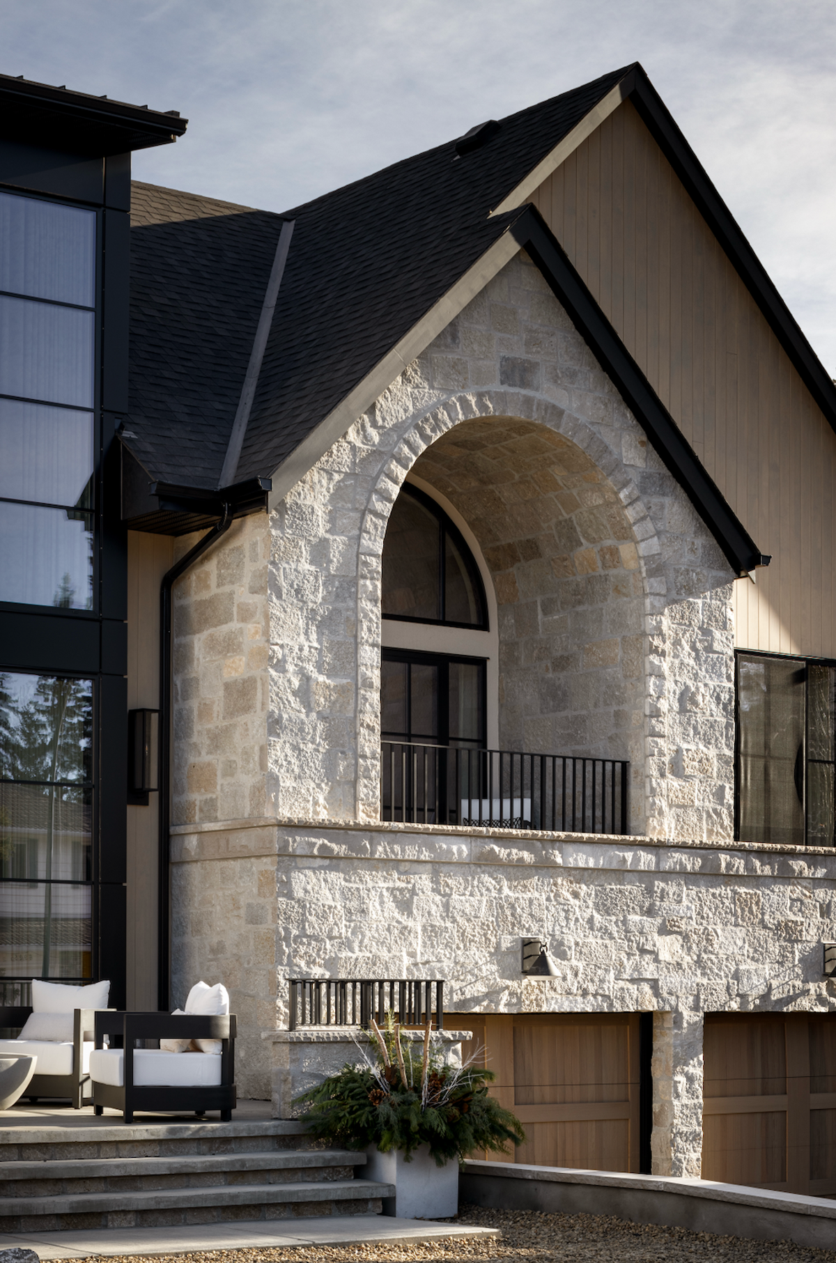 Stone exterior with arched balcony and garage doors