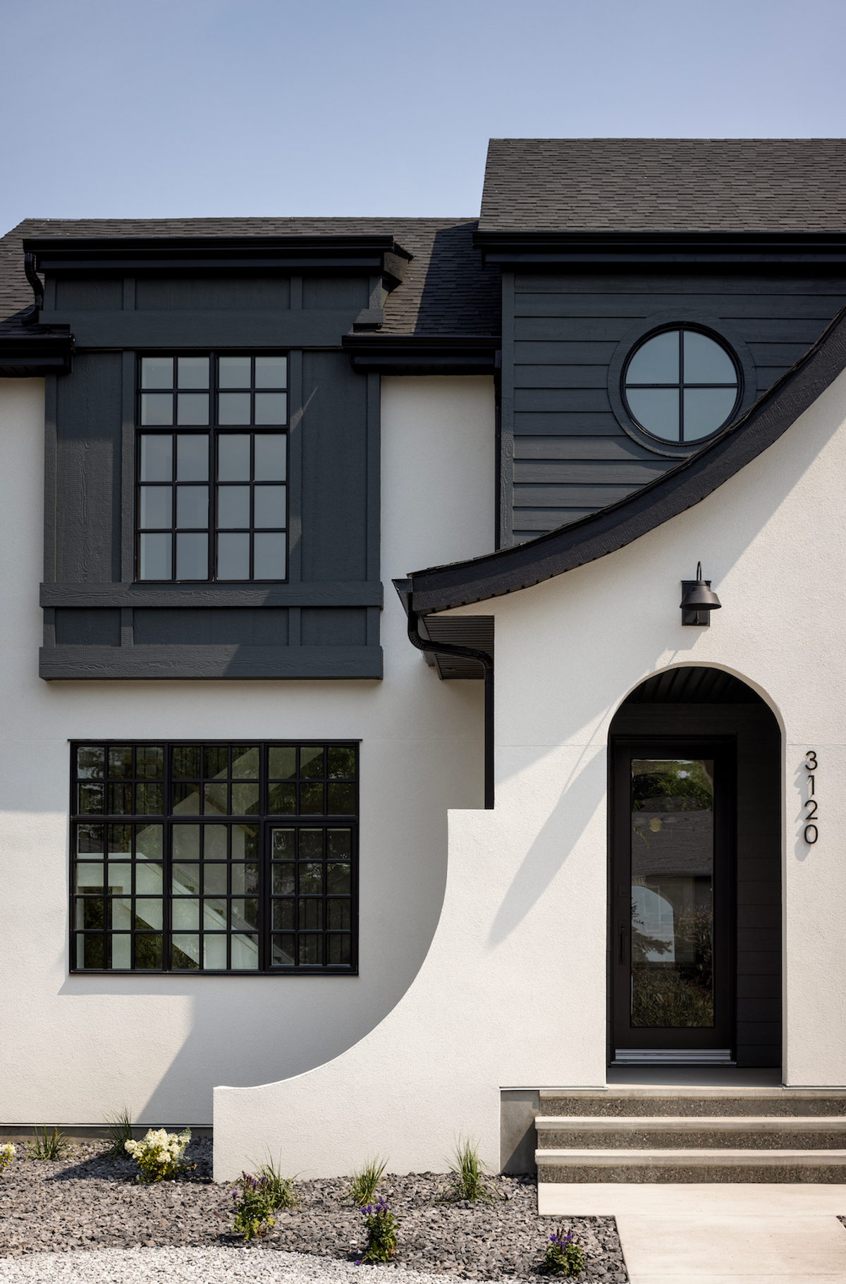 White stucco entry with curved wall and black trim