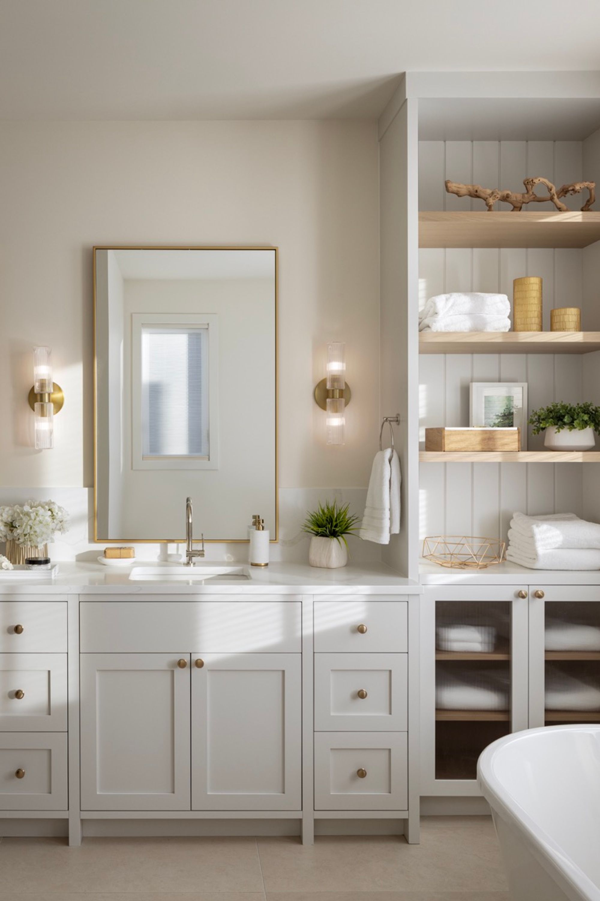 Bathroom vanity with gold mirror and open shelving in the Riverdale home