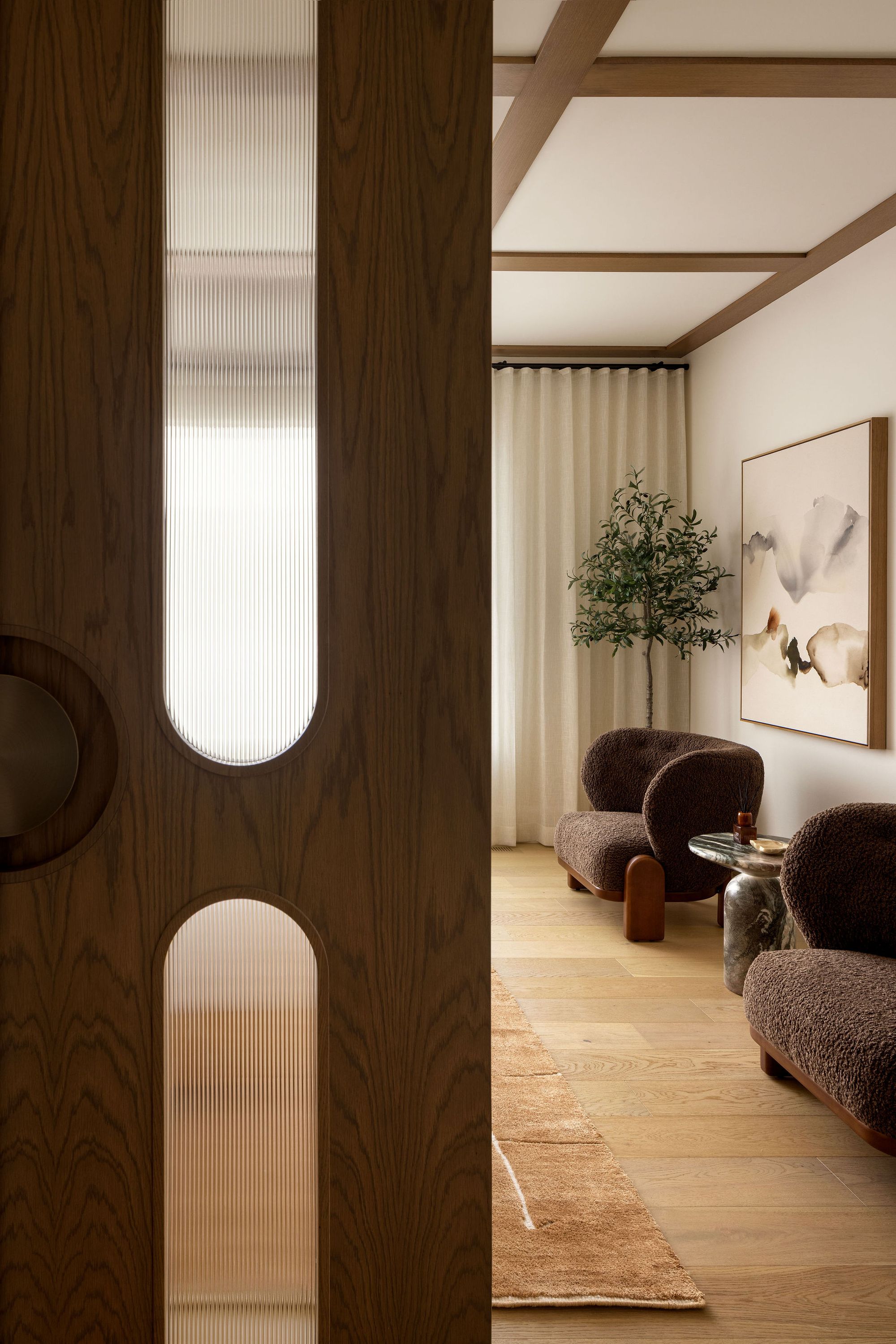 Sitting room seen through a wood door in The Charlotte home