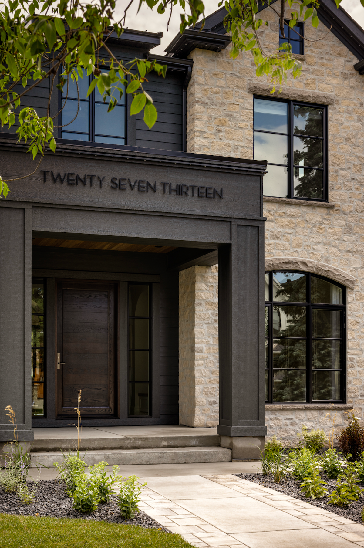 Dark entry portico beside a stone facade