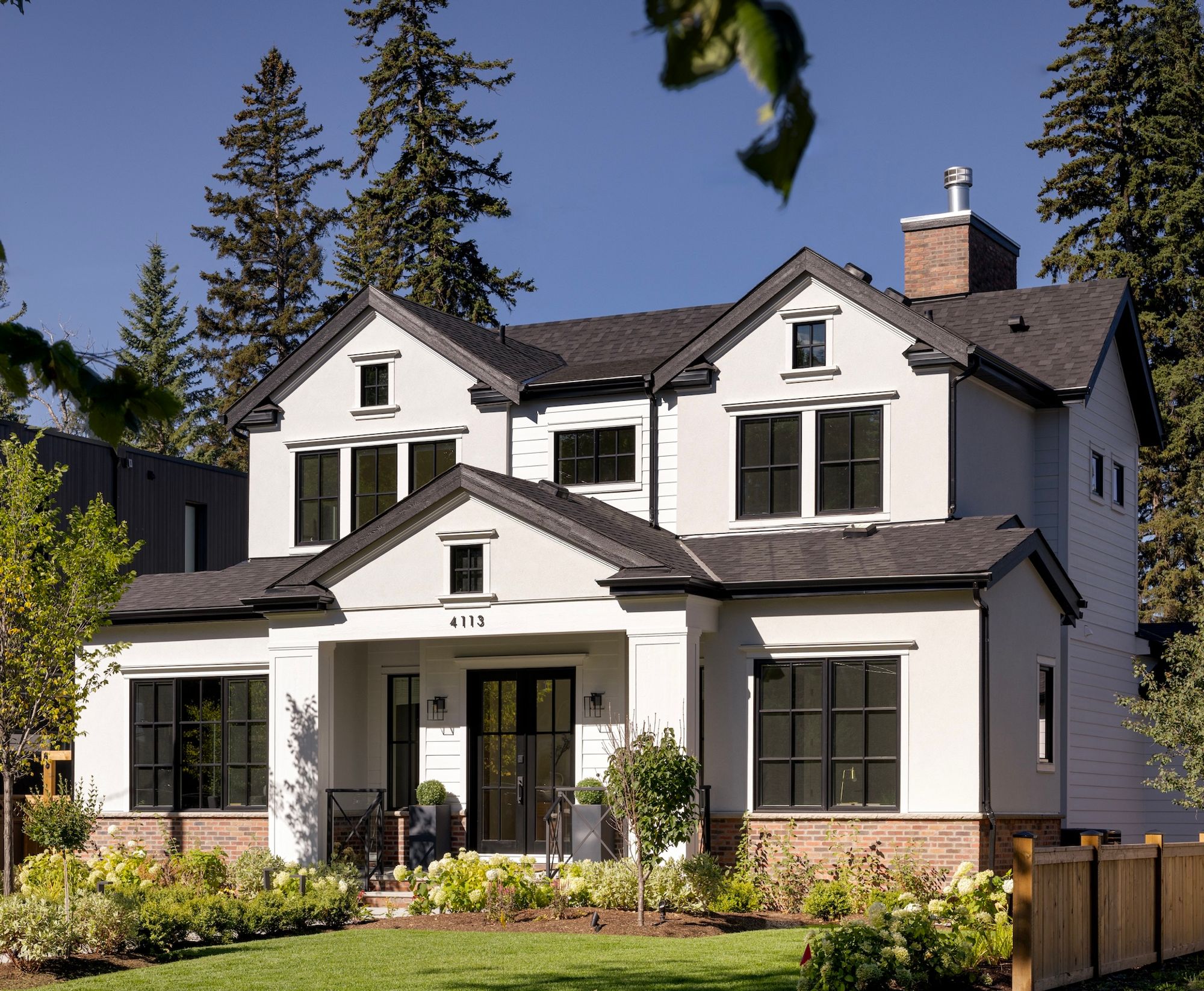 Front and side exterior of the Riverdale home with mature trees