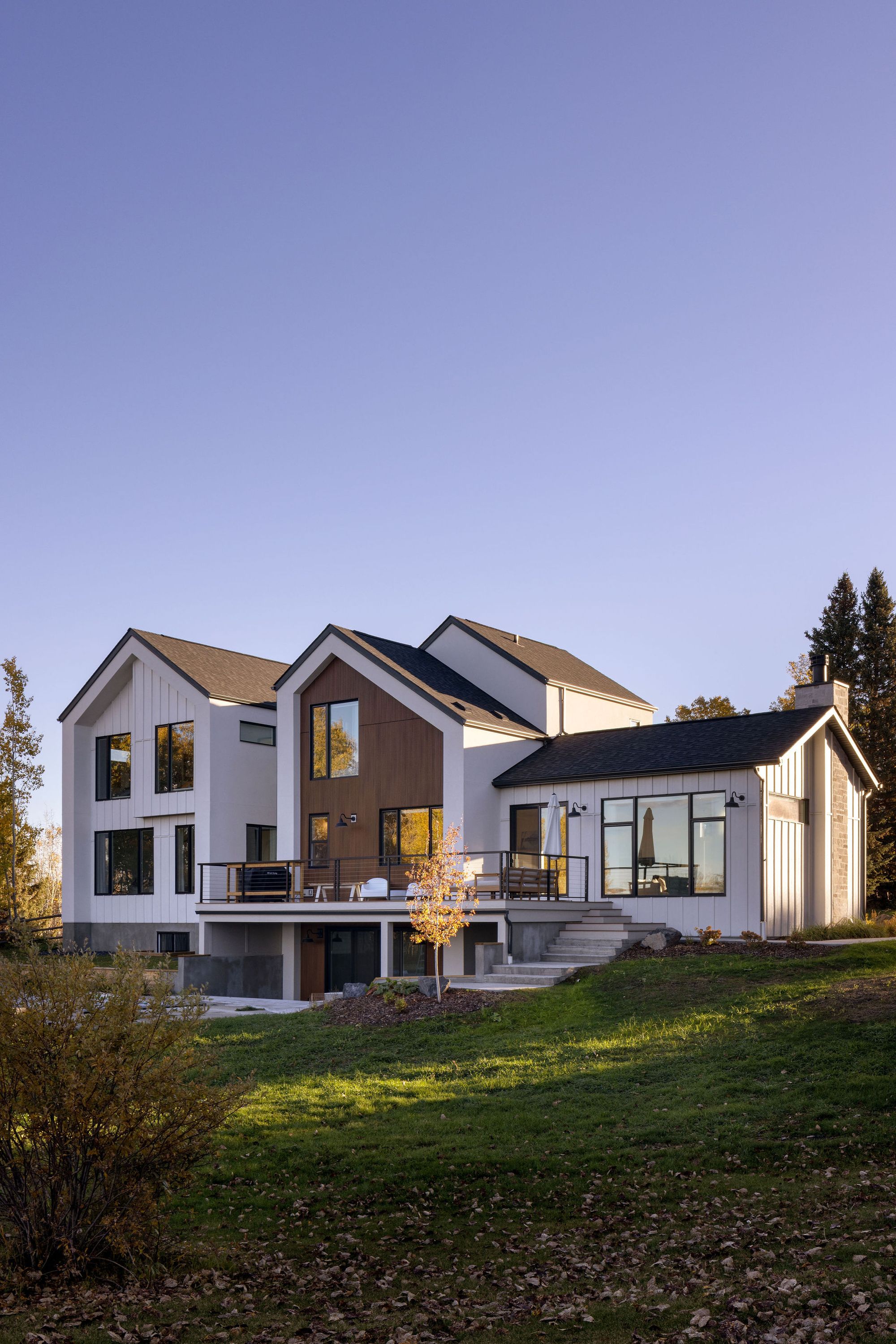 Rear of the Priddis home with deck at dusk