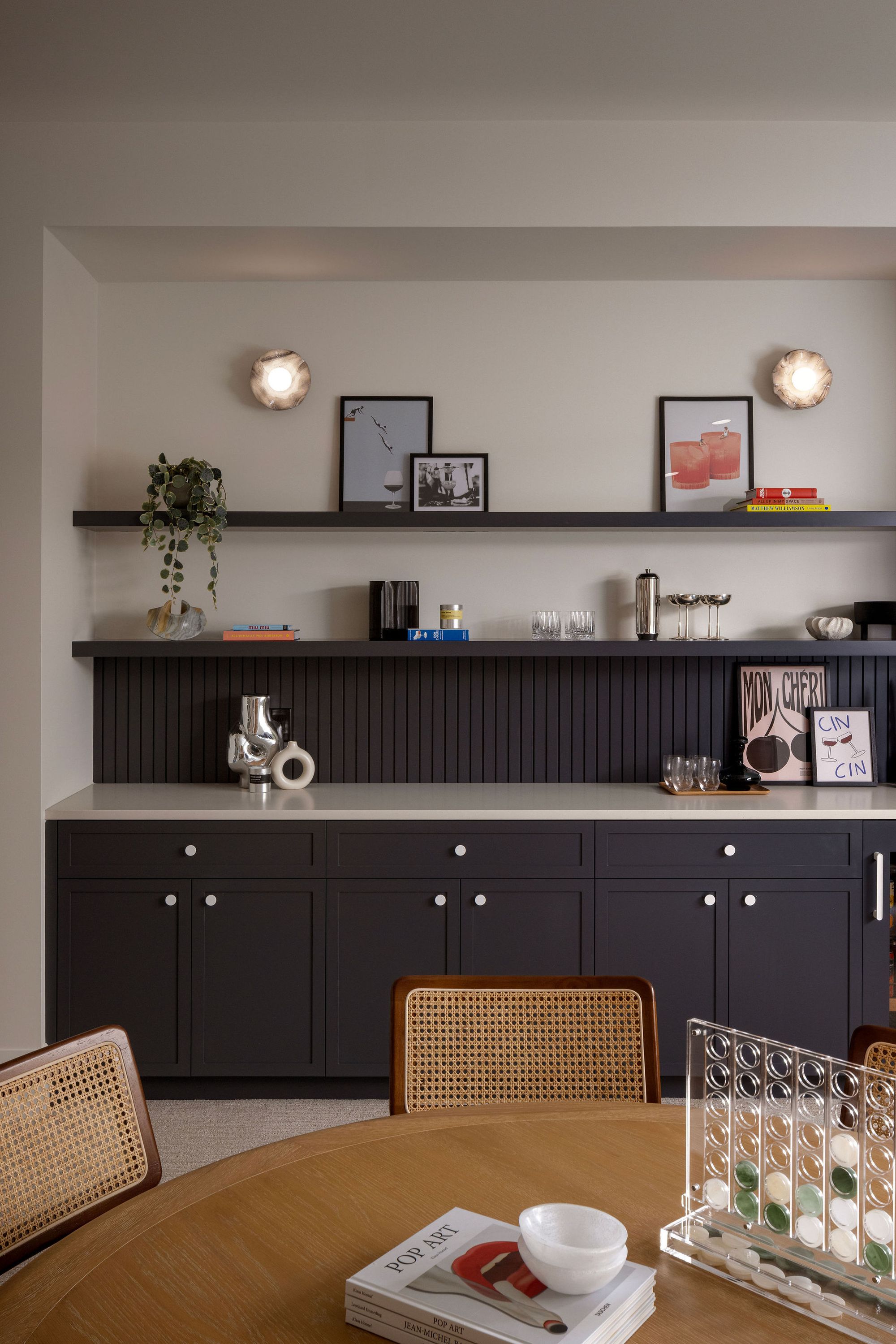 Dining area with navy sideboard and shelves in The Charlotte home