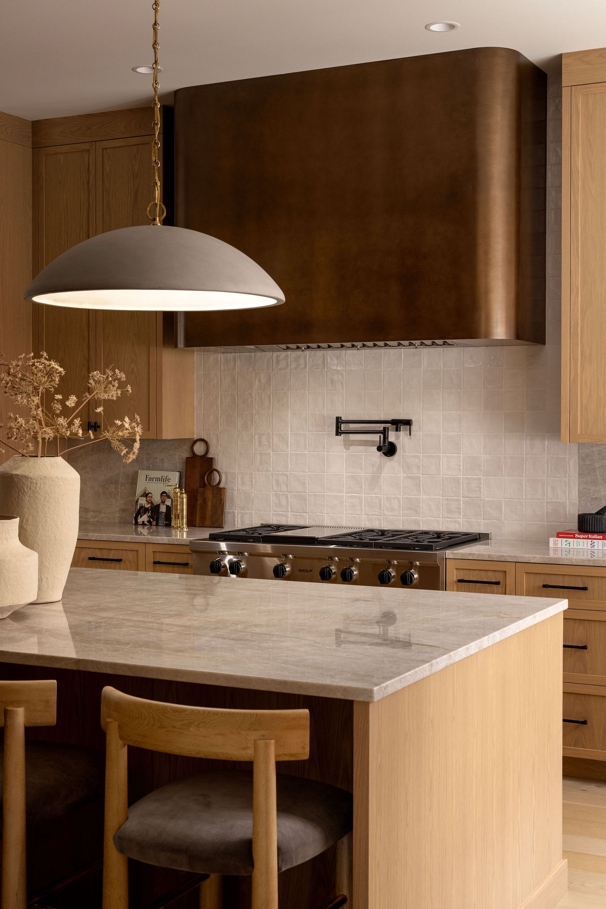 Kitchen with wood range hood and island in The Charlotte home