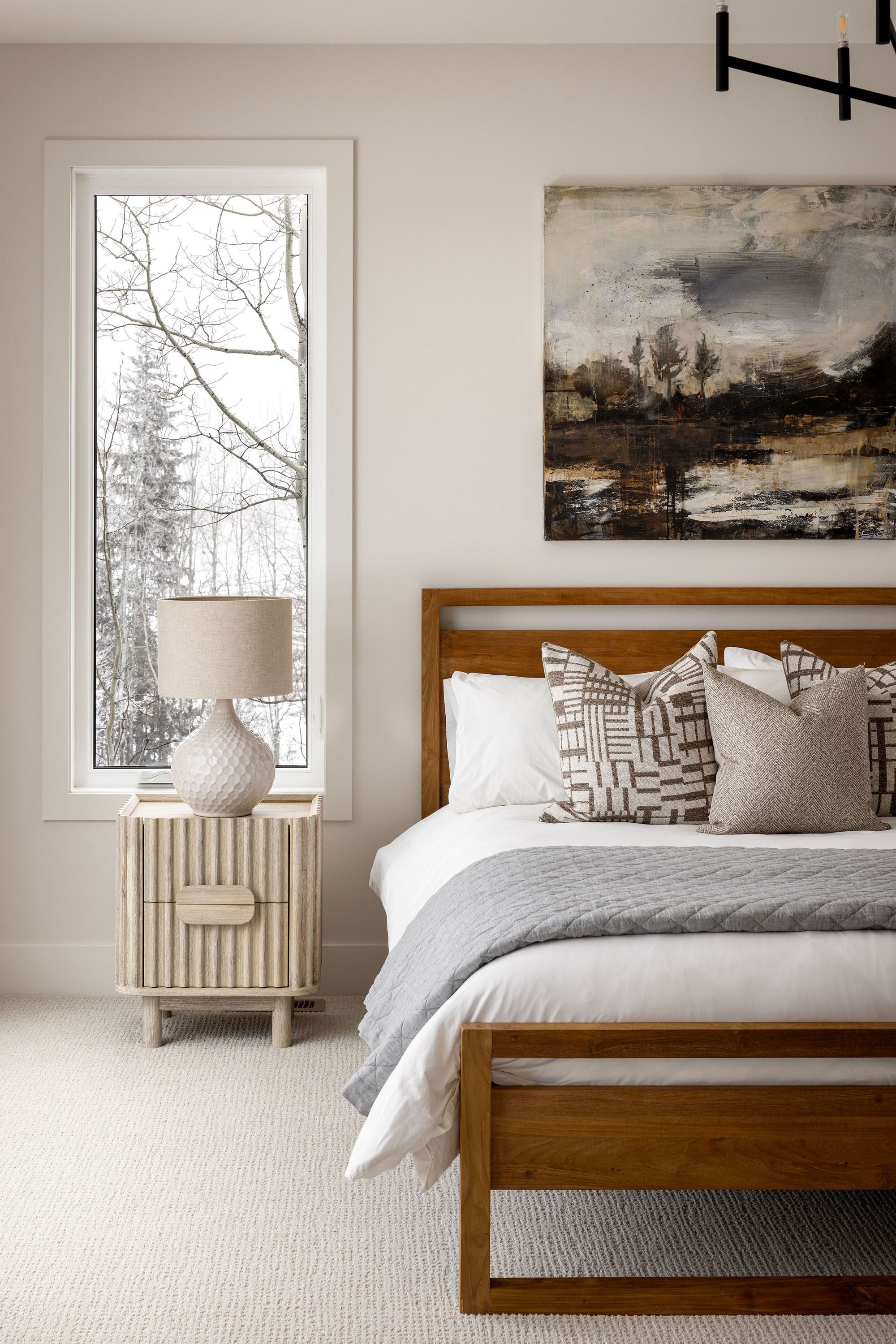 Bedroom with a wood bed frame in the Priddis home
