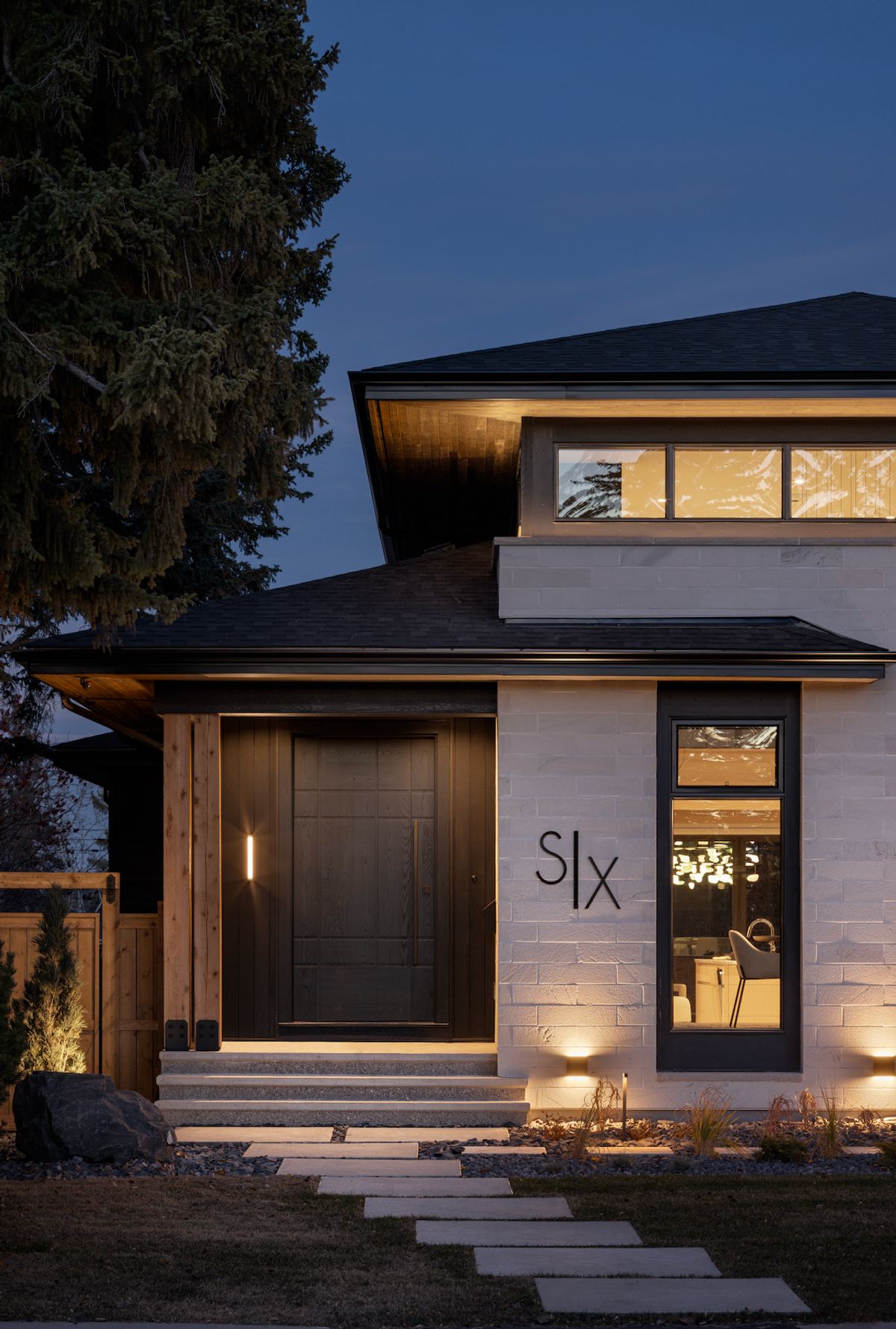 Front entry at night with lit steps and a dark door