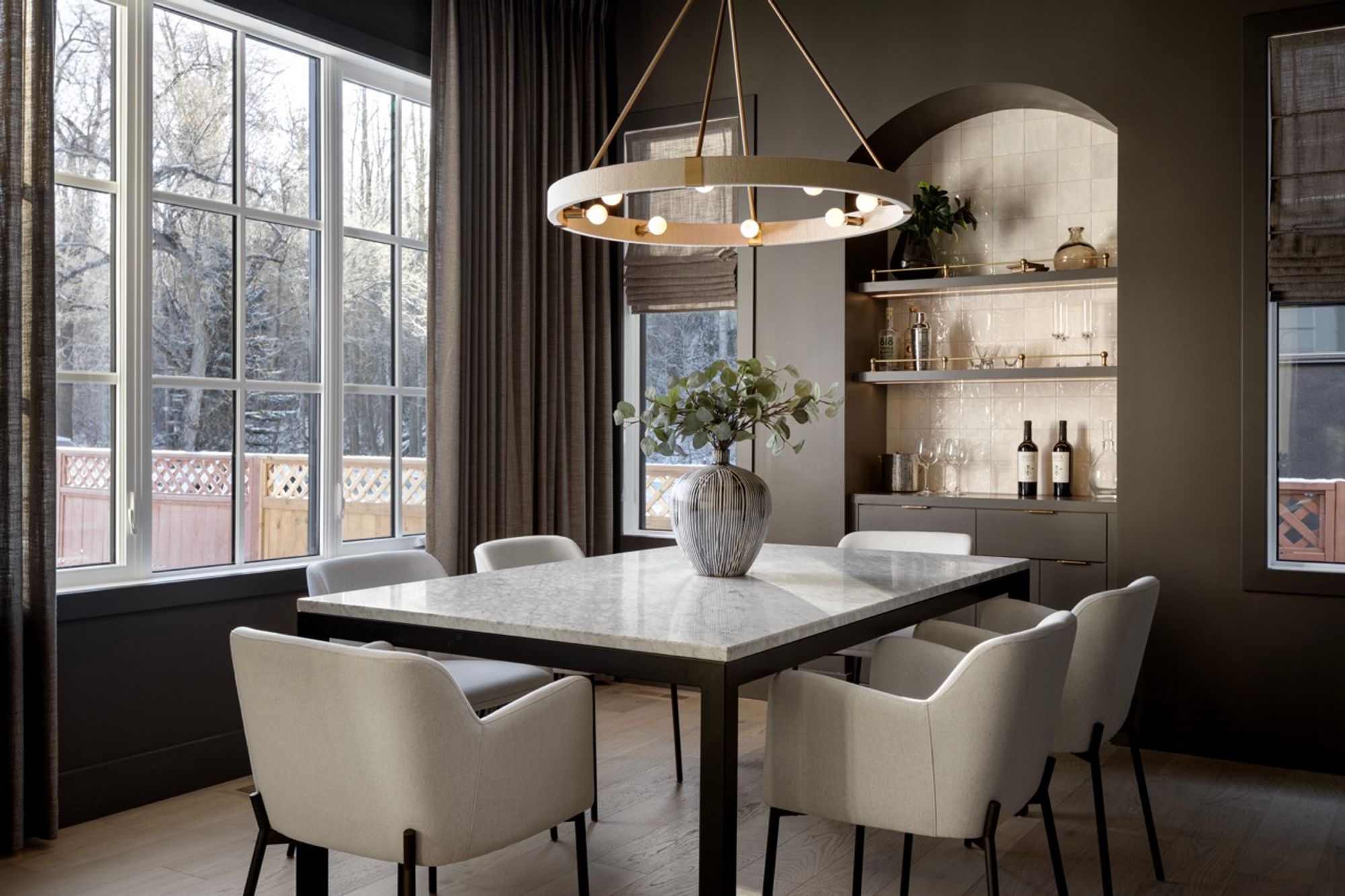 Dining room with marble table and arched bar niche in the Riverdale home