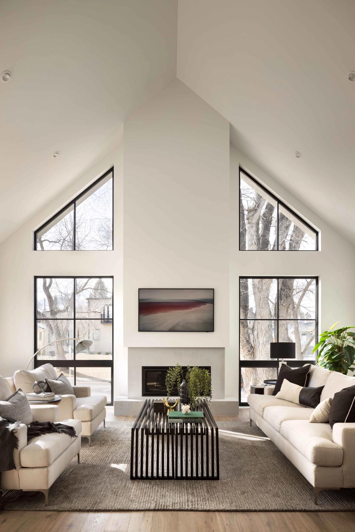Living room with a fireplace beneath gabled windows