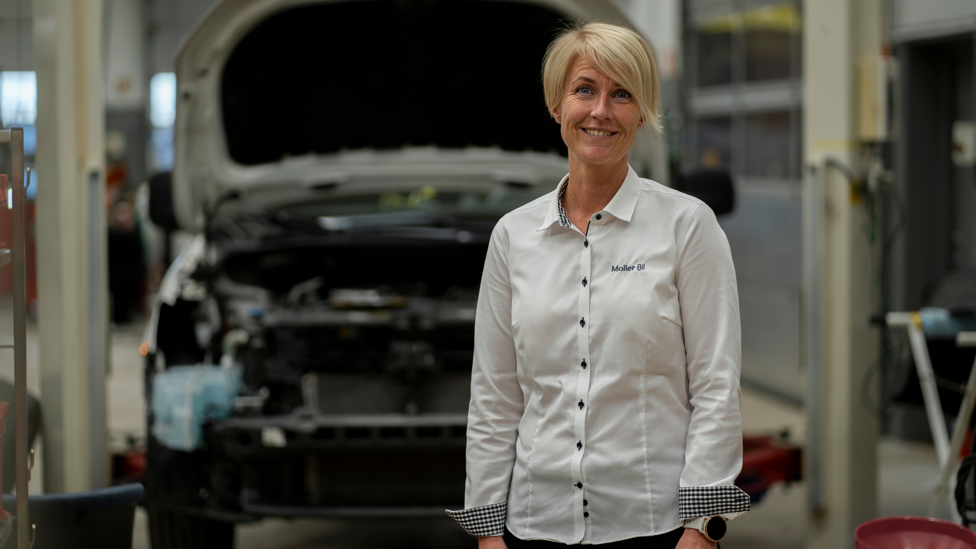 Serviceleder hos Møller Bil foran bil på verkstedet