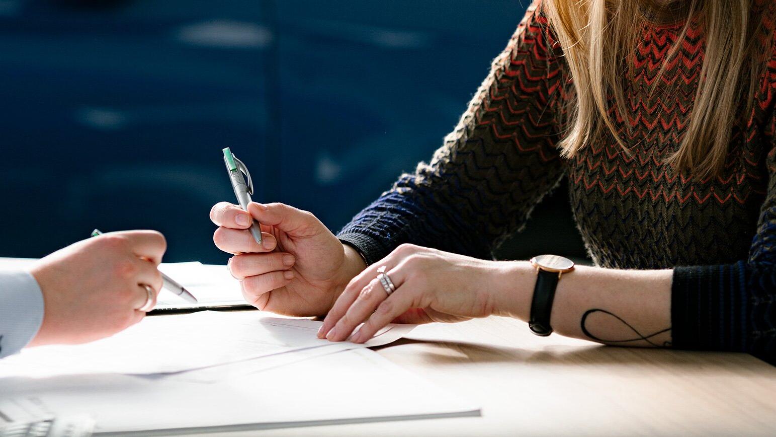 Kunde og Møller Bil ansatt som sitter og signerer kontrakt på bil