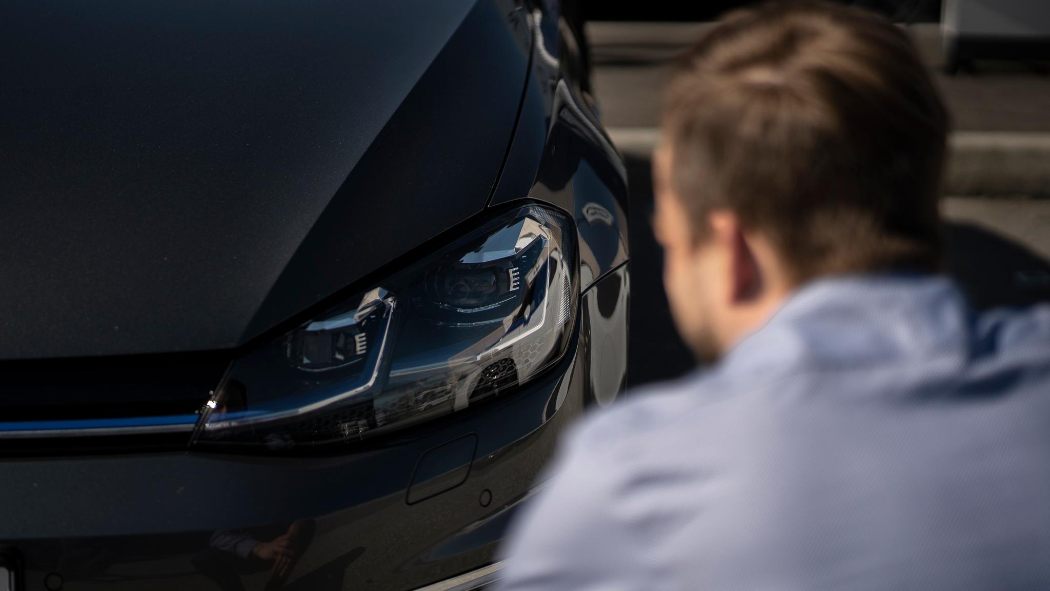 En person som ser på frontlyktene på bilen