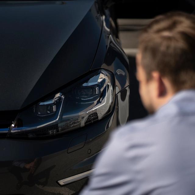 En person som ser på frontlyktene på bilen