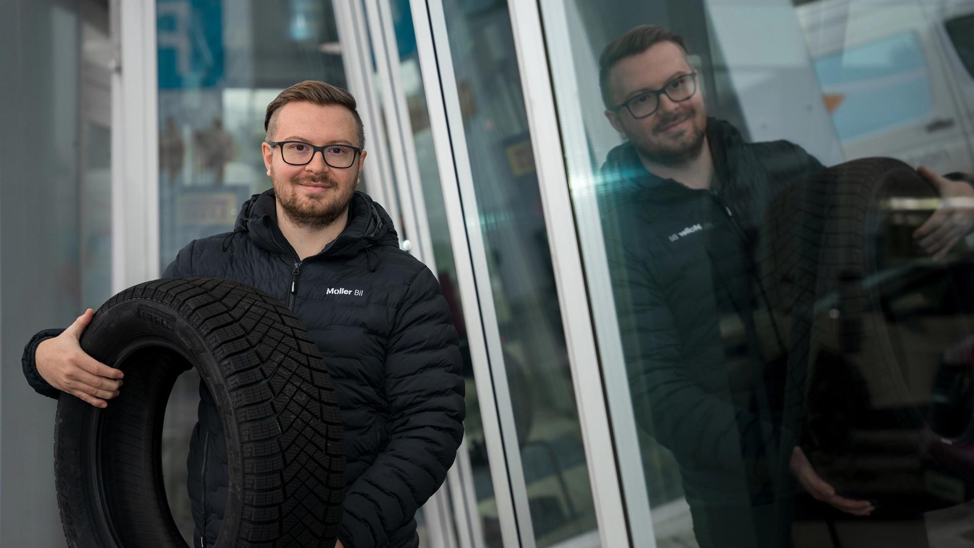 En Møller Bil ansatt som holder et dekk