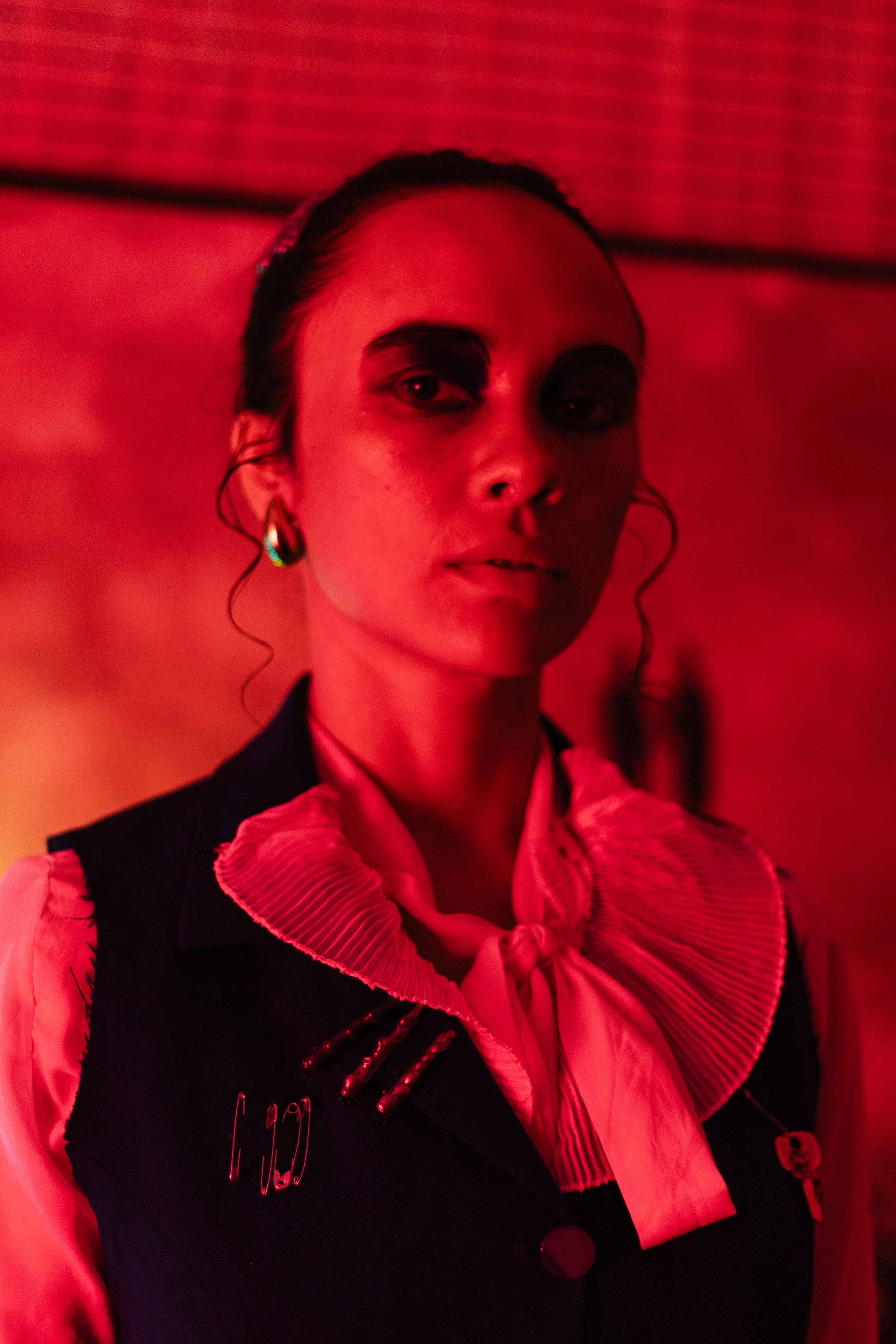 Retrato de mulher com gola plissada sob luz vermelha