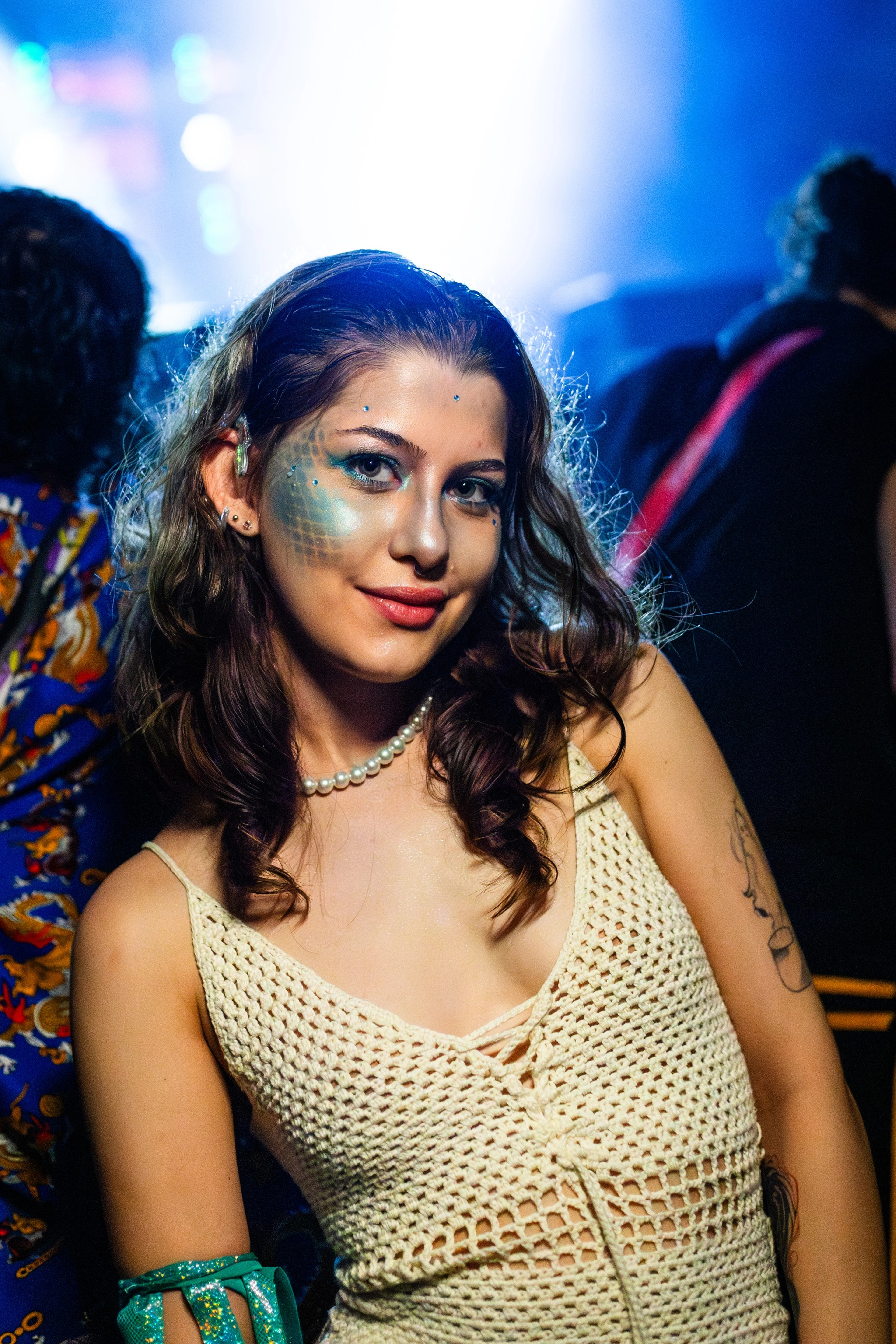 Mulher com maquiagem de sereia sorrindo numa festa