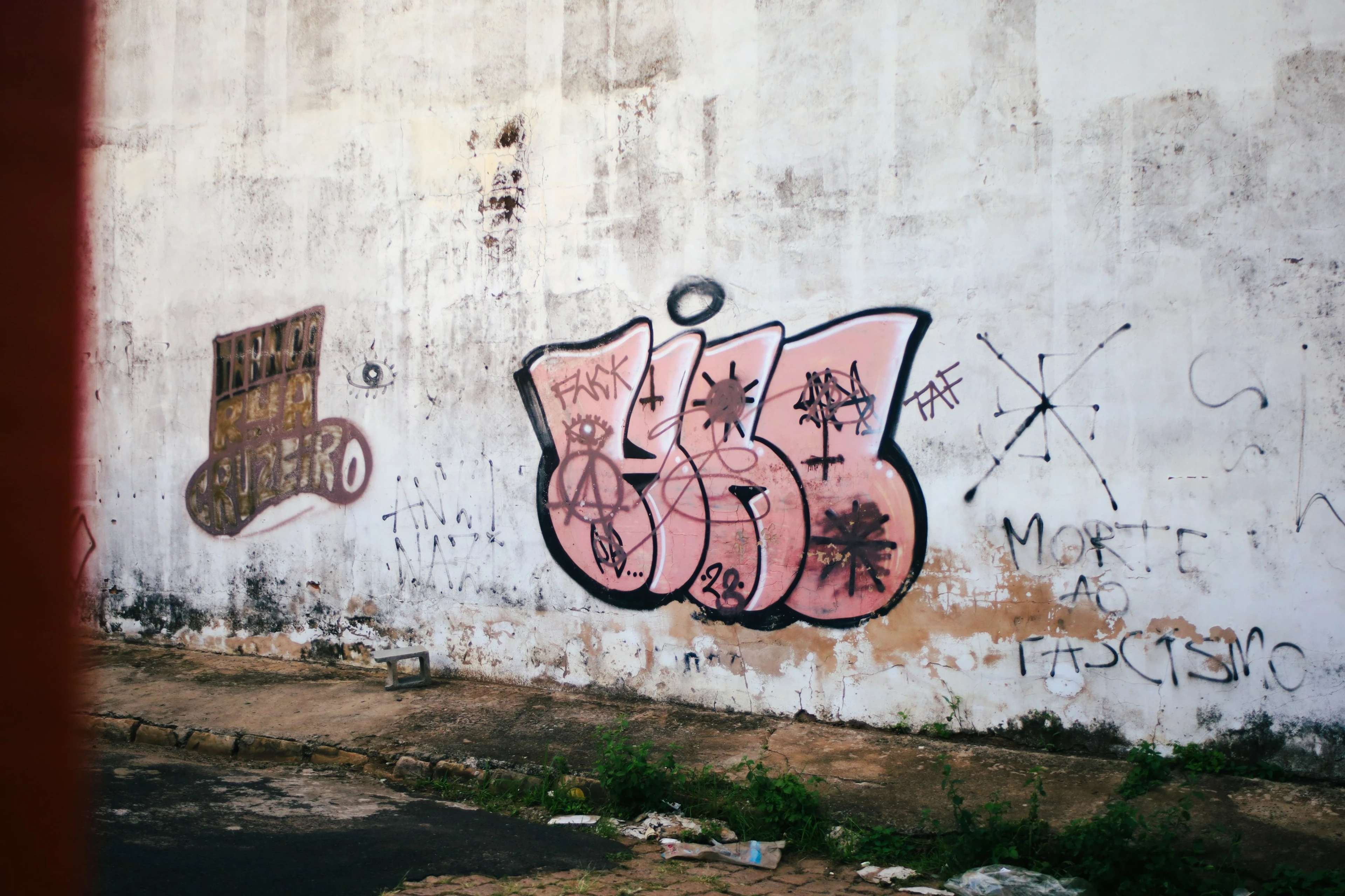 Muro branco desgastado coberto de pichações e grafites