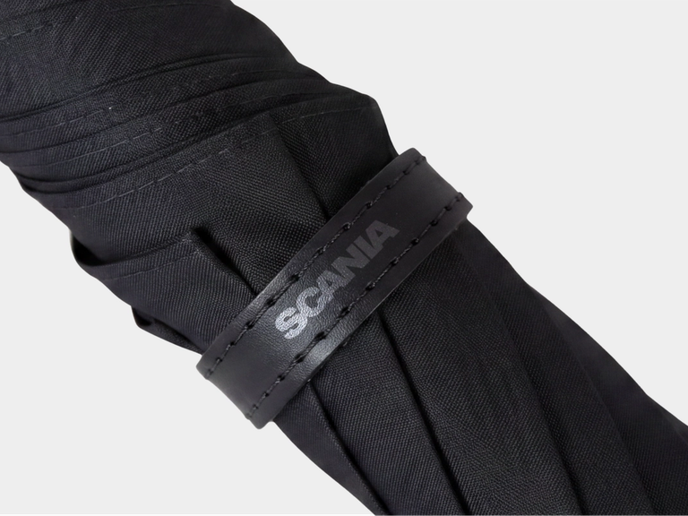 Closeup of black umbrella with Scania logotype.