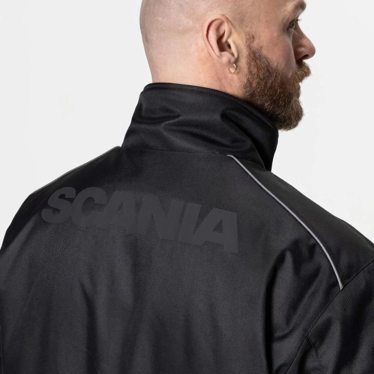 Man wearing black jacket with black Scania logotype on the back.