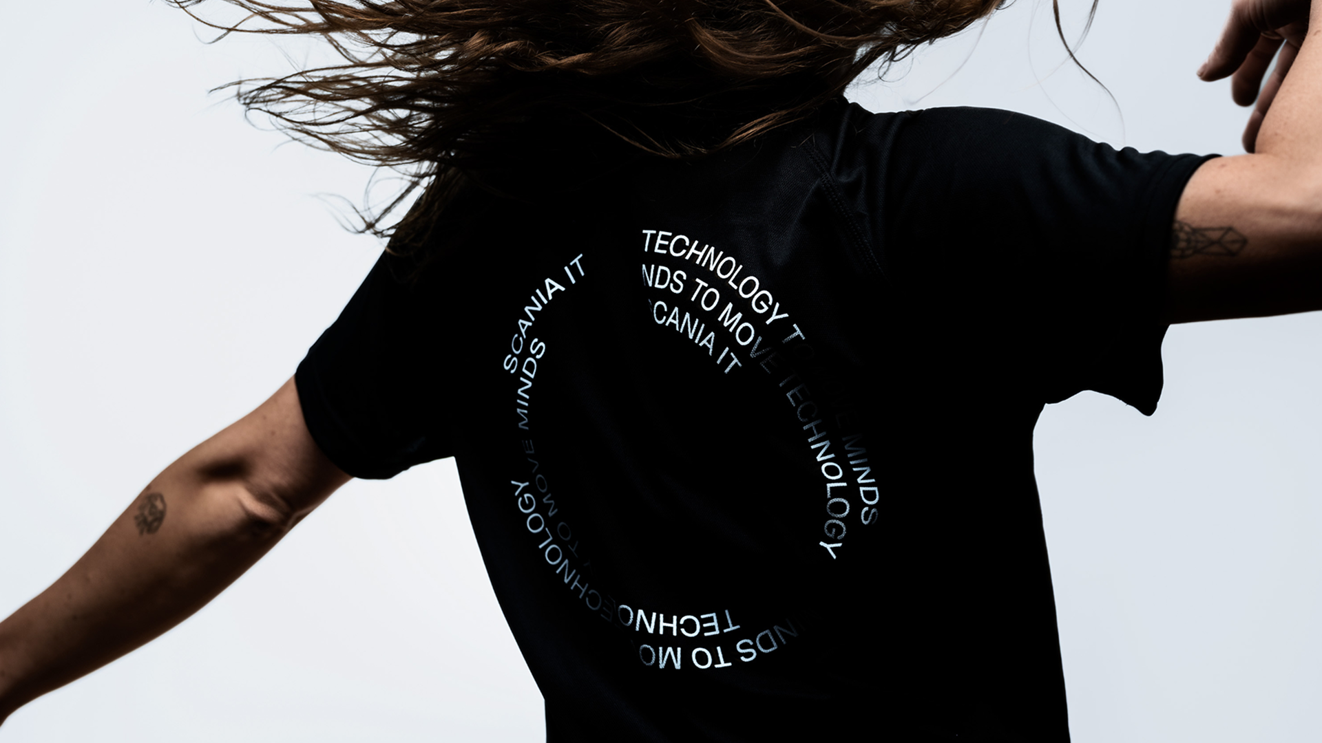 Person in motion wearing a black Scania running t-shirt.