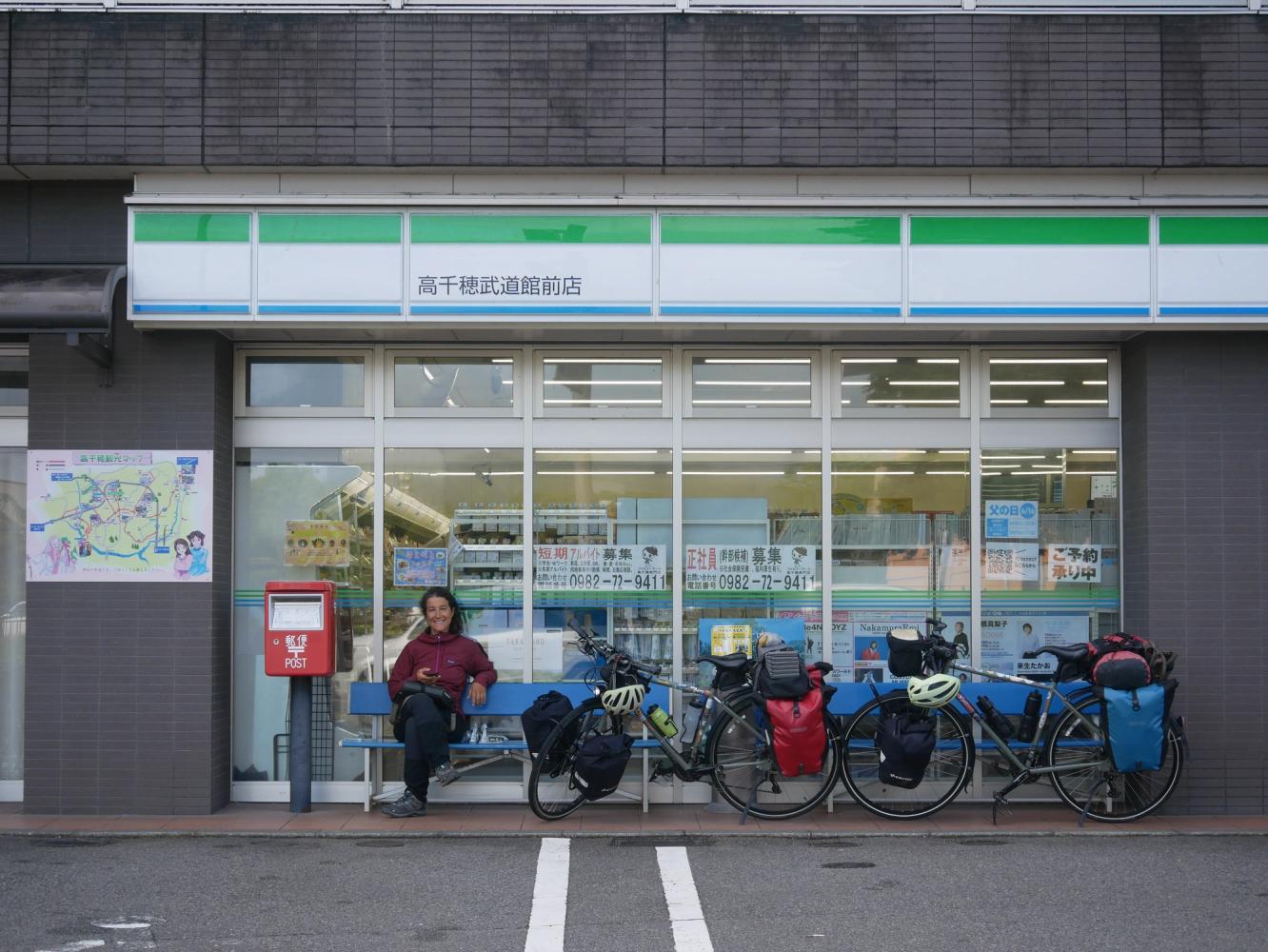 Jeune femme devant un magasin au Japon et les deux vélos devant l'enseigne