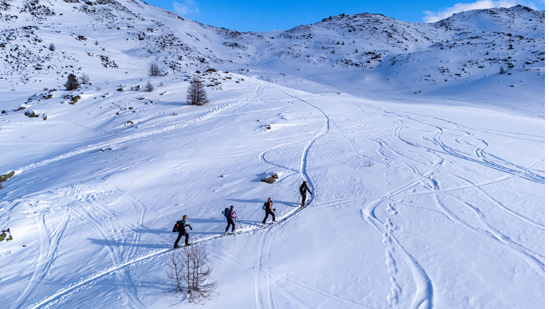 4 personnes en ski de randonnée dans la montagne vus d'en haut