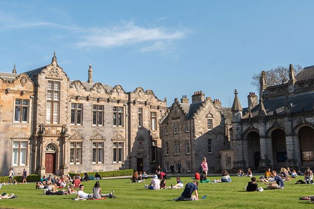 Students sitting on the lawn at St Andrews University campus during IMC visit