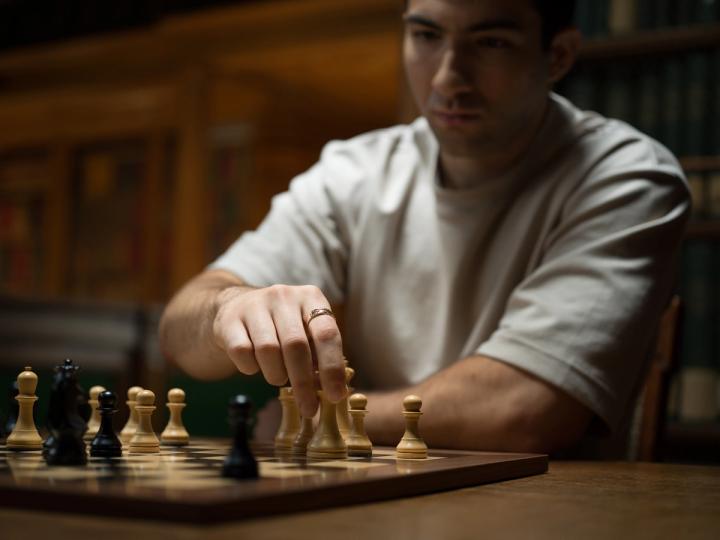 IMC trader Murad moving a chess piece during a match