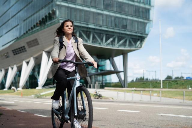 Woman on bike in front of office building