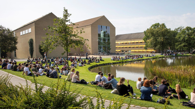 Students gathered by the lake at Aarhus University campus during IMC visit