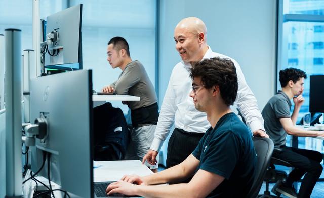 Andrew Fong mentoring employees at IMC’s Hong Kong office trading floor