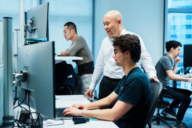 Andrew Fong mentoring employees at IMC’s Hong Kong office trading floor