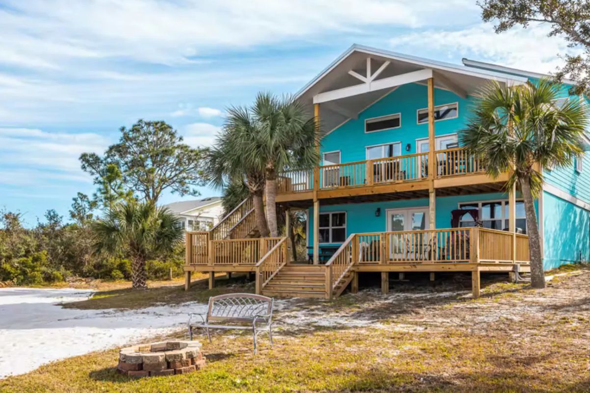 A two-story turquoise beach house with wooden decks, palm trees, a fire pit, and a bench in a sandy yard.​​​​‌﻿‍﻿​‍​‍‌‍﻿﻿‌﻿​‍‌‍‍‌‌‍‌﻿‌‍‍‌‌‍﻿‍​‍​‍​﻿‍‍​‍​‍‌﻿​﻿‌‍​‌‌‍﻿‍‌‍‍‌‌﻿‌​‌﻿‍‌​‍﻿‍‌‍‍‌‌‍﻿﻿​‍​‍​‍﻿​​‍​‍‌‍‍​‌﻿​‍‌‍‌‌‌‍‌‍​‍​‍​﻿‍‍​‍​‍​‍﻿﻿‌﻿​﻿‌﻿‌​‌﻿‌‌‌‍‌​‌‍‍‌‌‍﻿﻿​‍﻿﻿‌‍‍‌‌‍﻿‍‌﻿‌​‌‍‌‌‌‍﻿‍‌﻿‌​​‍﻿﻿‌‍‌‌‌‍‌​‌‍‍‌‌﻿‌​​‍﻿﻿‌‍﻿‌‌‍﻿﻿‌‍‌​‌‍‌‌​﻿﻿‌‌﻿​​‌﻿​‍‌‍‌‌‌﻿​﻿‌‍‌‌‌‍﻿‍‌﻿‌​‌‍​‌‌﻿‌​‌‍‍‌‌‍﻿﻿‌‍﻿‍​﻿‍﻿‌‍‍‌‌‍‌​​﻿﻿‌​﻿​‌‌‍‌‍‌‍​﻿​﻿​‍​﻿‌​​﻿​‍​﻿‍‌​﻿​​​‍﻿‌‌‍‌‍‌‍​‍​﻿‌﻿‌‍‌‍​‍﻿‌​﻿‌​‌‍‌​‌‍‌‌​﻿​​​‍﻿‌‌‍​‌​﻿​‌‌‍‌​‌‍​‌​‍﻿‌‌‍​﻿‌‍​‌​﻿‌‌‌‍‌​‌‍‌‌​﻿‌﻿​﻿‌​‌‍‌‌​﻿‌‍​﻿‌‍‌‍‌​‌‍‌‌​﻿‍﻿‌﻿‌​‌﻿‍‌‌﻿​​‌‍‌‌​﻿﻿‌‌﻿​​‌‍﻿﻿‌﻿​﻿‌﻿‌​​﻿‍﻿‌﻿​​‌‍​‌‌﻿‌​‌‍‍​​﻿﻿‌‌‍​﻿‌‍﻿﻿‌﻿‌‍‌‍‌‌‌﻿​‍‌​‍‌‌‍﻿‌‌‍​‌‌‍‌﻿‌‍‌‌​‍﻿‍‌‍​‌‌‍﻿​‌﻿‌​​﻿﻿﻿‌‍​‍‌‍​‌‌﻿​﻿‌‍‌‌‌‌‌‌‌﻿​‍‌‍﻿​​﻿﻿‌​‍‌‌​﻿​‍‌​‌‍‌﻿​﻿‌﻿‌​‌﻿‌‌‌‍‌​‌‍‍‌‌‍﻿﻿​‍‌‍‌‍‍‌‌‍‌​​﻿﻿‌​﻿​‌‌‍‌‍‌‍​﻿​﻿​‍​﻿‌​​﻿​‍​﻿‍‌​﻿​​​‍﻿‌‌‍‌‍‌‍​‍​﻿‌﻿‌‍‌‍​‍﻿‌​﻿‌​‌‍‌​‌‍‌‌​﻿​​​‍﻿‌‌‍​‌​﻿​‌‌‍‌​‌‍​‌​‍﻿‌‌‍​﻿‌‍​‌​﻿‌‌‌‍‌​‌‍‌‌​﻿‌﻿​﻿‌​‌‍‌‌​﻿‌‍​﻿‌‍‌‍‌​‌‍‌‌​‍‌‍‌﻿‌​‌﻿‍‌‌﻿​​‌‍‌‌​﻿﻿‌‌﻿​​‌‍﻿﻿‌﻿​﻿‌﻿‌​​‍‌‍‌﻿​​‌‍​‌‌﻿‌​‌‍‍​​﻿﻿‌‌‍​﻿‌‍﻿﻿‌﻿‌‍‌‍‌‌‌﻿​‍‌​‍‌‌‍﻿‌‌‍​‌‌‍‌﻿‌‍‌‌​‍﻿‍‌‍​‌‌‍﻿​‌﻿‌​​‍‌‍‌﻿​​‌‍‌‌‌﻿​‍‌﻿​﻿‌﻿​​‌‍‌‌‌‍​﻿‌﻿‌​‌‍‍‌‌﻿‌‍‌‍‌‌​﻿﻿‌‌﻿​​‌﻿‌‌‌‍​‍‌‍﻿​‌‍‍‌‌﻿​﻿‌‍‍​‌‍‌‌‌‍‌​​‍​‍‌﻿﻿‌