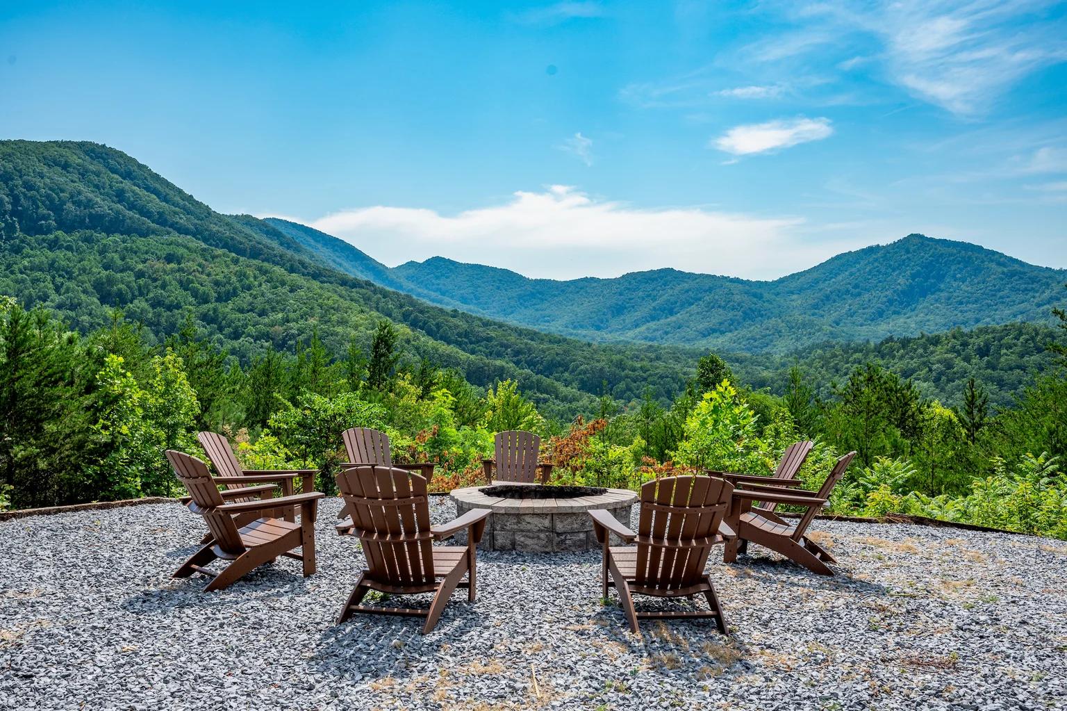 A fire pit surrounded by Adirondack chairs on a gravel patio with a panoramic view of lush green mountains under a blue sky.​​​​‌﻿‍﻿​‍​‍‌‍﻿﻿‌﻿​‍‌‍‍‌‌‍‌﻿‌‍‍‌‌‍﻿‍​‍​‍​﻿‍‍​‍​‍‌﻿​﻿‌‍​‌‌‍﻿‍‌‍‍‌‌﻿‌​‌﻿‍‌​‍﻿‍‌‍‍‌‌‍﻿﻿​‍​‍​‍﻿​​‍​‍‌‍‍​‌﻿​‍‌‍‌‌‌‍‌‍​‍​‍​﻿‍‍​‍​‍​‍﻿﻿‌﻿​﻿‌﻿‌​‌﻿‌‌‌‍‌​‌‍‍‌‌‍﻿﻿​‍﻿﻿‌‍‍‌‌‍﻿‍‌﻿‌​‌‍‌‌‌‍﻿‍‌﻿‌​​‍﻿﻿‌‍‌‌‌‍‌​‌‍‍‌‌﻿‌​​‍﻿﻿‌‍﻿‌‌‍﻿﻿‌‍‌​‌‍‌‌​﻿﻿‌‌﻿​​‌﻿​‍‌‍‌‌‌﻿​﻿‌‍‌‌‌‍﻿‍‌﻿‌​‌‍​‌‌﻿‌​‌‍‍‌‌‍﻿﻿‌‍﻿‍​﻿‍﻿‌‍‍‌‌‍‌​​﻿﻿‌​﻿‍​​﻿​​‌‍​‌‌‍‌‌​﻿​​​﻿‍‌‌‍‌​‌‍​﻿​‍﻿‌​﻿‍​‌‍​‌​﻿‌‍​﻿​‍​‍﻿‌​﻿‌​‌‍‌​​﻿‌‍​﻿‍‌​‍﻿‌‌‍​‍​﻿​​​﻿‍‌​﻿​​​‍﻿‌‌‍‌‍‌‍​﻿​﻿​‌​﻿​​‌‍‌‍‌‍​﻿‌‍‌​​﻿‍​​﻿​﻿‌‍‌‍‌‍‌​​﻿‌​​﻿‍﻿‌﻿‌​‌﻿‍‌‌﻿​​‌‍‌‌​﻿﻿‌‌﻿​​‌‍﻿﻿‌﻿​﻿‌﻿‌​​﻿‍﻿‌﻿​​‌‍​‌‌﻿‌​‌‍‍​​﻿﻿‌‌‍​﻿‌‍﻿﻿‌﻿‌‍‌‍‌‌‌﻿​‍‌​‍‌‌‍﻿‌‌‍​‌‌‍‌﻿‌‍‌‌​‍﻿‍‌‍​‌‌‍﻿​‌﻿‌​​﻿﻿﻿‌‍​‍‌‍​‌‌﻿​﻿‌‍‌‌‌‌‌‌‌﻿​‍‌‍﻿​​﻿﻿‌​‍‌‌​﻿​‍‌​‌‍‌﻿​﻿‌﻿‌​‌﻿‌‌‌‍‌​‌‍‍‌‌‍﻿﻿​‍‌‍‌‍‍‌‌‍‌​​﻿﻿‌​﻿‍​​﻿​​‌‍​‌‌‍‌‌​﻿​​​﻿‍‌‌‍‌​‌‍​﻿​‍﻿‌​﻿‍​‌‍​‌​﻿‌‍​﻿​‍​‍﻿‌​﻿‌​‌‍‌​​﻿‌‍​﻿‍‌​‍﻿‌‌‍​‍​﻿​​​﻿‍‌​﻿​​​‍﻿‌‌‍‌‍‌‍​﻿​﻿​‌​﻿​​‌‍‌‍‌‍​﻿‌‍‌​​﻿‍​​﻿​﻿‌‍‌‍‌‍‌​​﻿‌​​‍‌‍‌﻿‌​‌﻿‍‌‌﻿​​‌‍‌‌​﻿﻿‌‌﻿​​‌‍﻿﻿‌﻿​﻿‌﻿‌​​‍‌‍‌﻿​​‌‍​‌‌﻿‌​‌‍‍​​﻿﻿‌‌‍​﻿‌‍﻿﻿‌﻿‌‍‌‍‌‌‌﻿​‍‌​‍‌‌‍﻿‌‌‍​‌‌‍‌﻿‌‍‌‌​‍﻿‍‌‍​‌‌‍﻿​‌﻿‌​​‍‌‍‌﻿​​‌‍‌‌‌﻿​‍‌﻿​﻿‌﻿​​‌‍‌‌‌‍​﻿‌﻿‌​‌‍‍‌‌﻿‌‍‌‍‌‌​﻿﻿‌‌﻿​​‌﻿‌‌‌‍​‍‌‍﻿​‌‍‍‌‌﻿​﻿‌‍‍​‌‍‌‌‌‍‌​​‍​‍‌﻿﻿‌