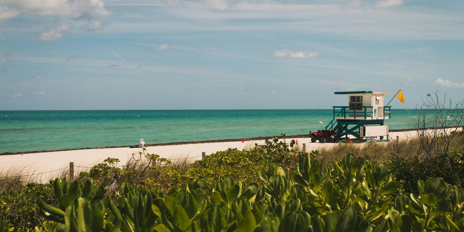 a lifeguard tower is sitting on the beach next to the ocean .