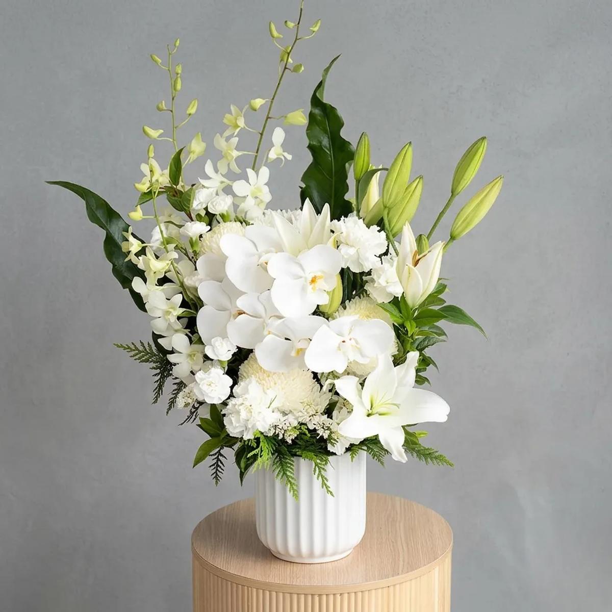 White and green arrangement in glass vase