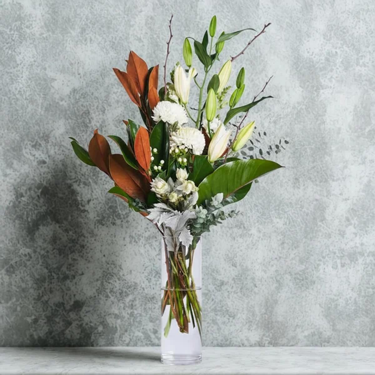 White orchids and lilies in dark vase