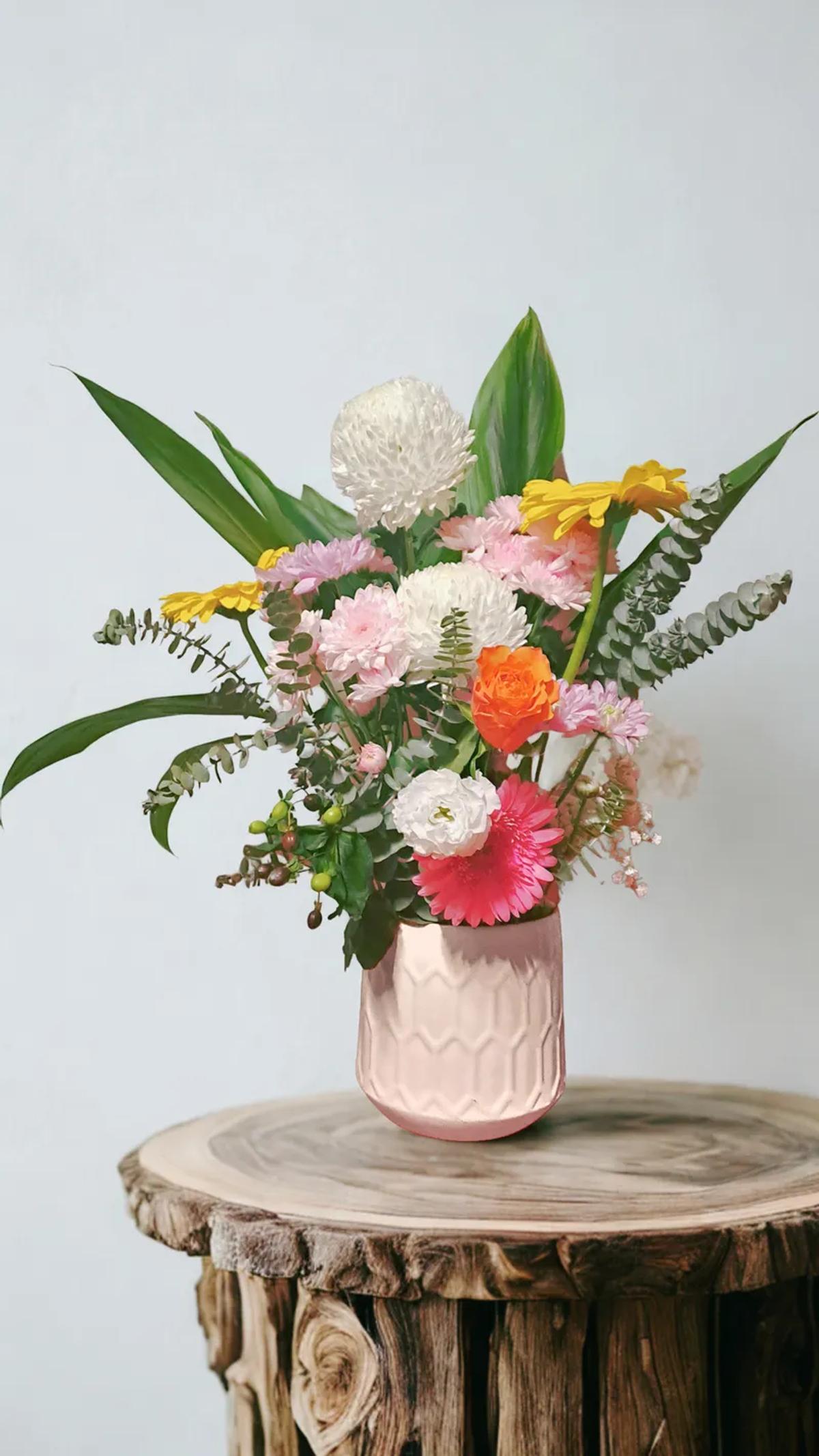 White lattice vase with roses, lilies and protea