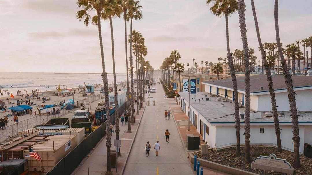 A view of a beach boardwalk during sunset.